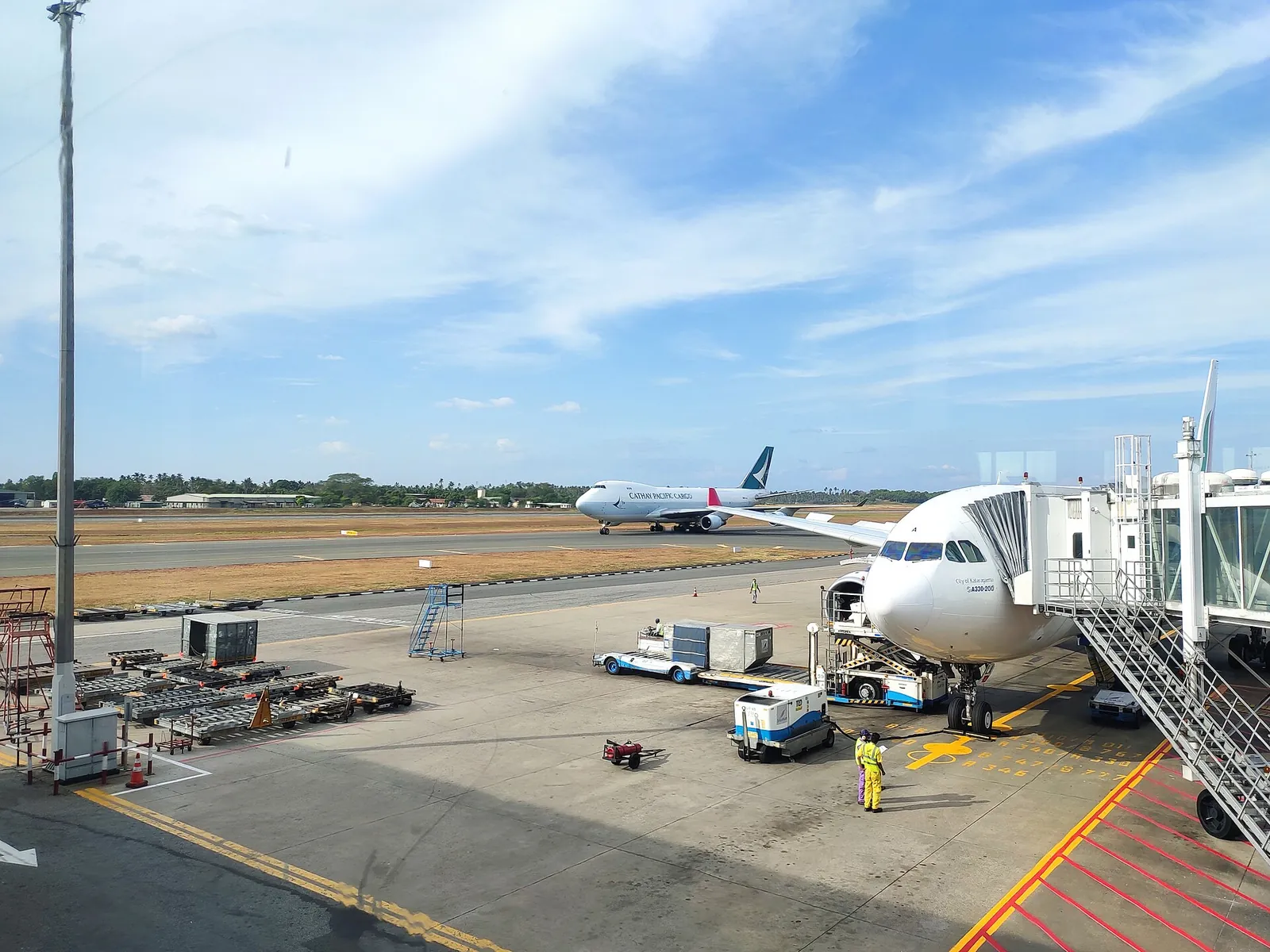 Un avión en una pasarela de embarque sobre la plataforma del aeropuerto internacional Bandaranaike, bajo un cielo azul