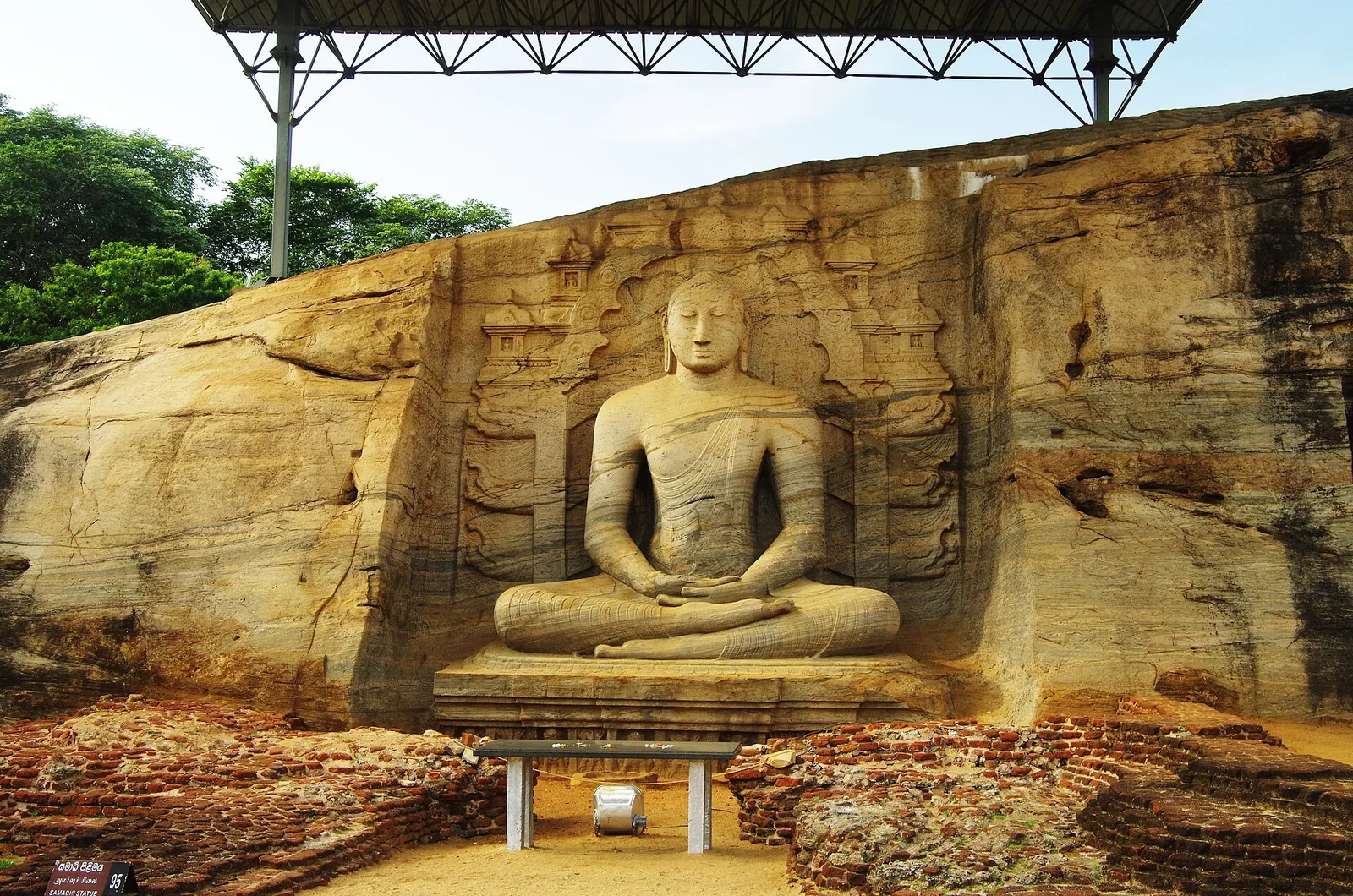 Buda sentado tallado en granito dorado bajo un tejado en Gal Vihara, Polonnaruwa