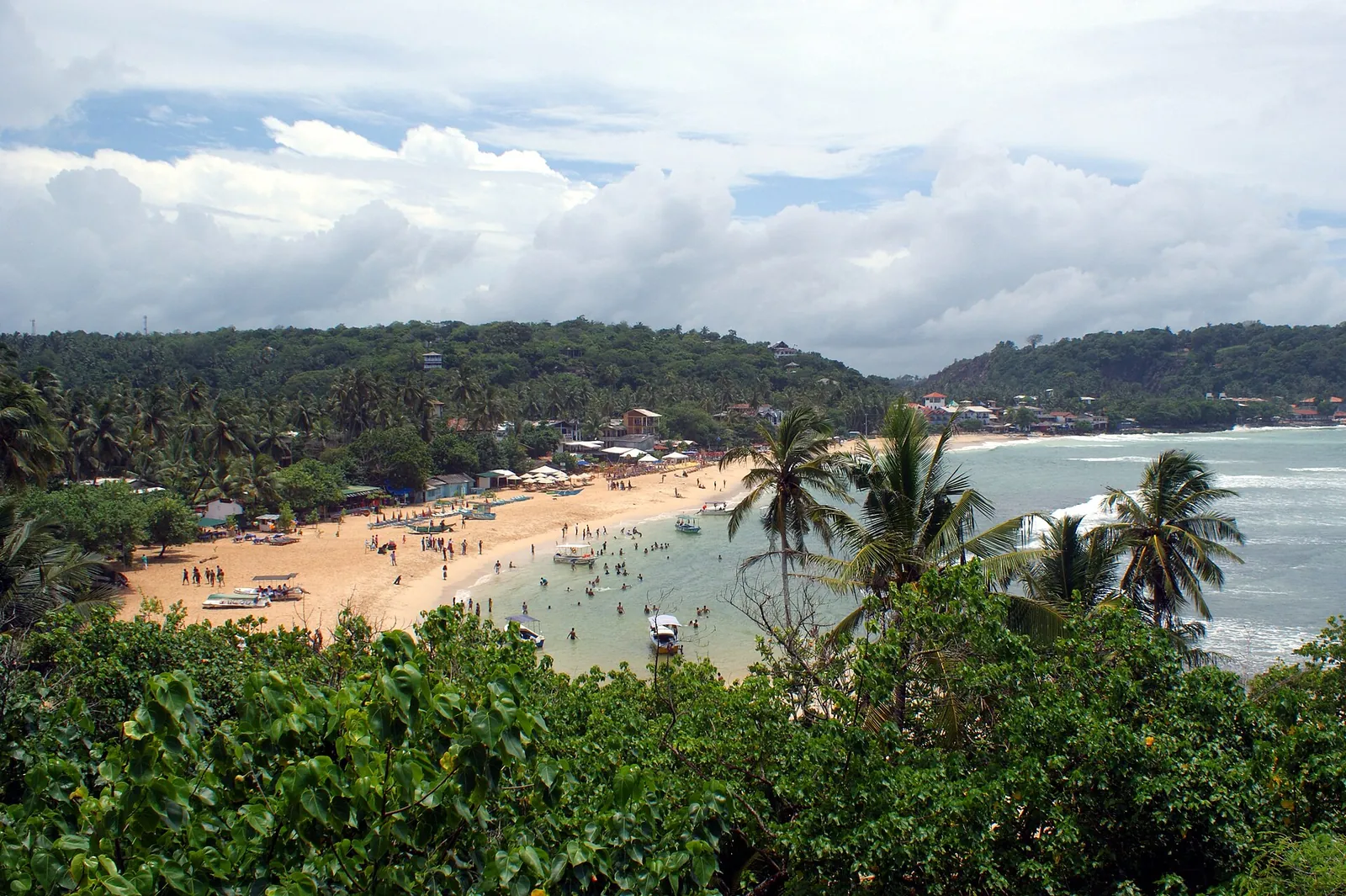 La bahía de Unawatuna vista desde arriba, con bañistas en la playa y promontorios arbolados