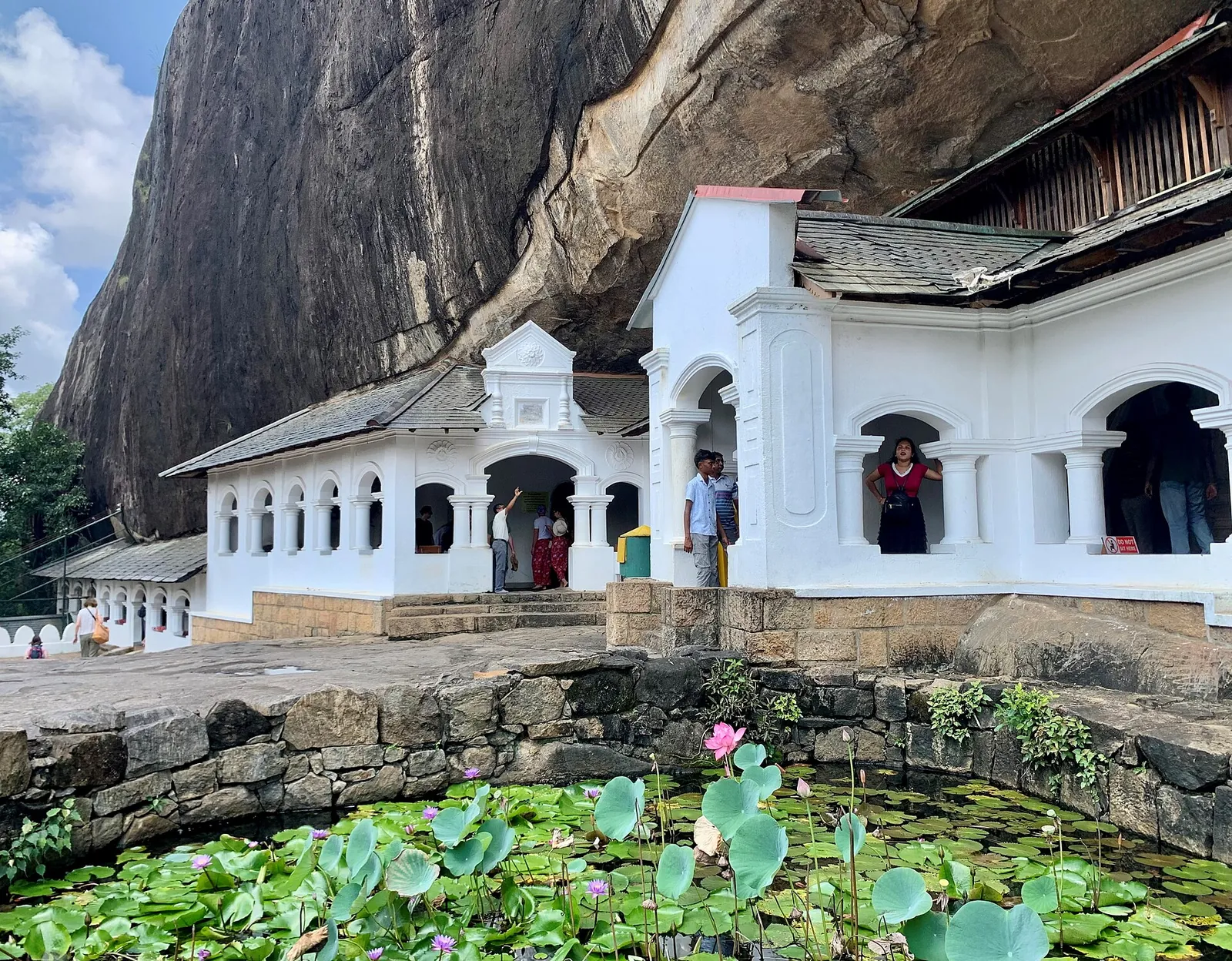 White entrance buildings of the Dambulla cave temple under the overhanging rock