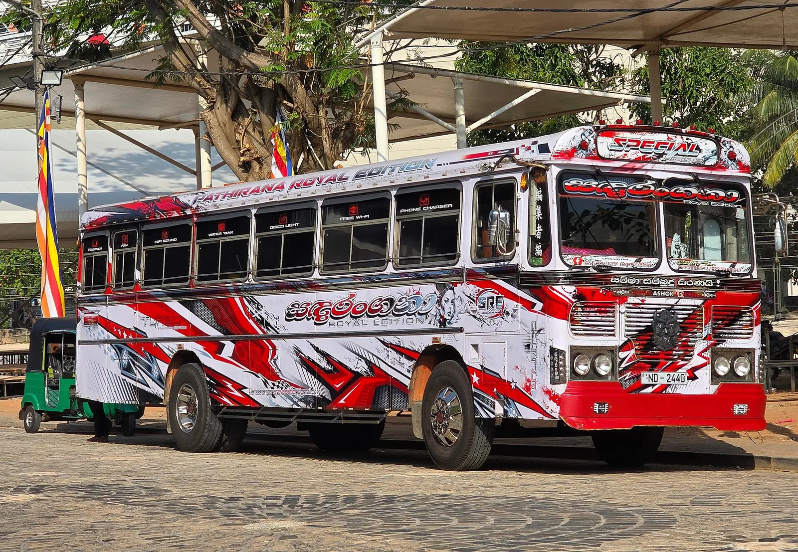 En rød og hvid bus på en gade i Colombo