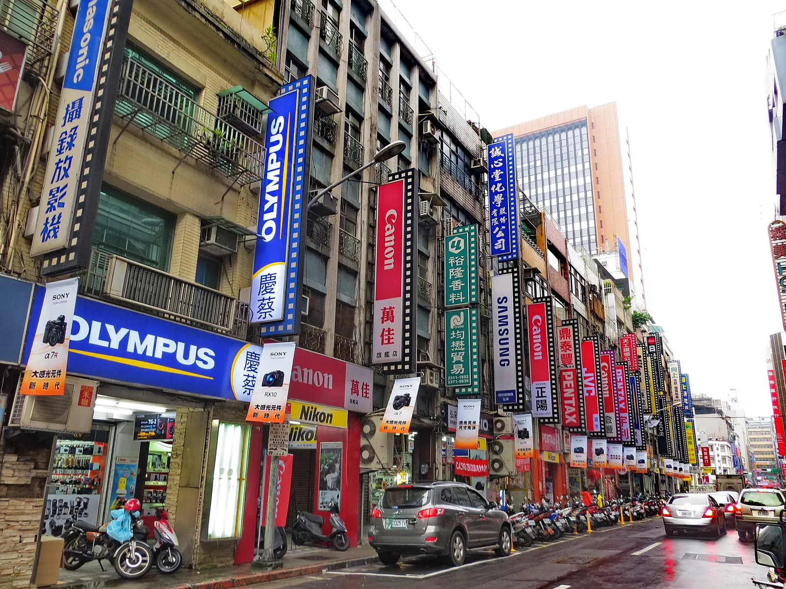 Tiendas de fotografía y tráfico en Hankou Street mojada por la lluvia, Taipei