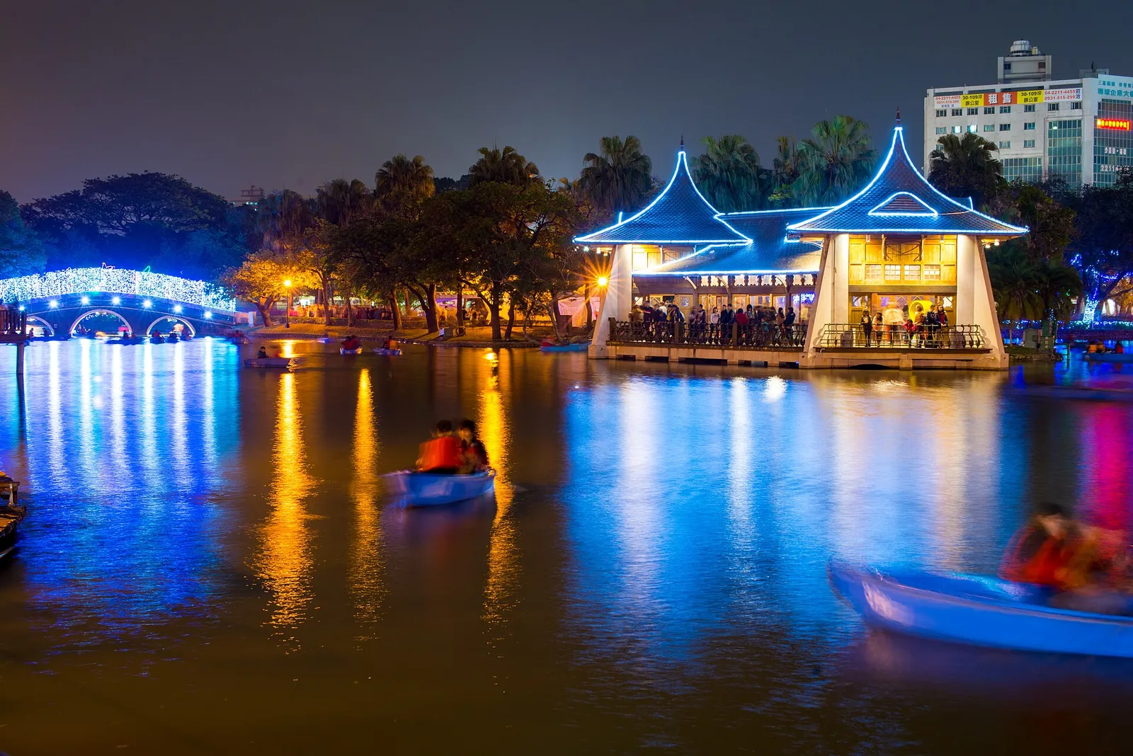 Oświetlone pawilony i most ozdobiony lampionami odbijają się nocą w jeziorze podczas Taiwan Lantern Festival