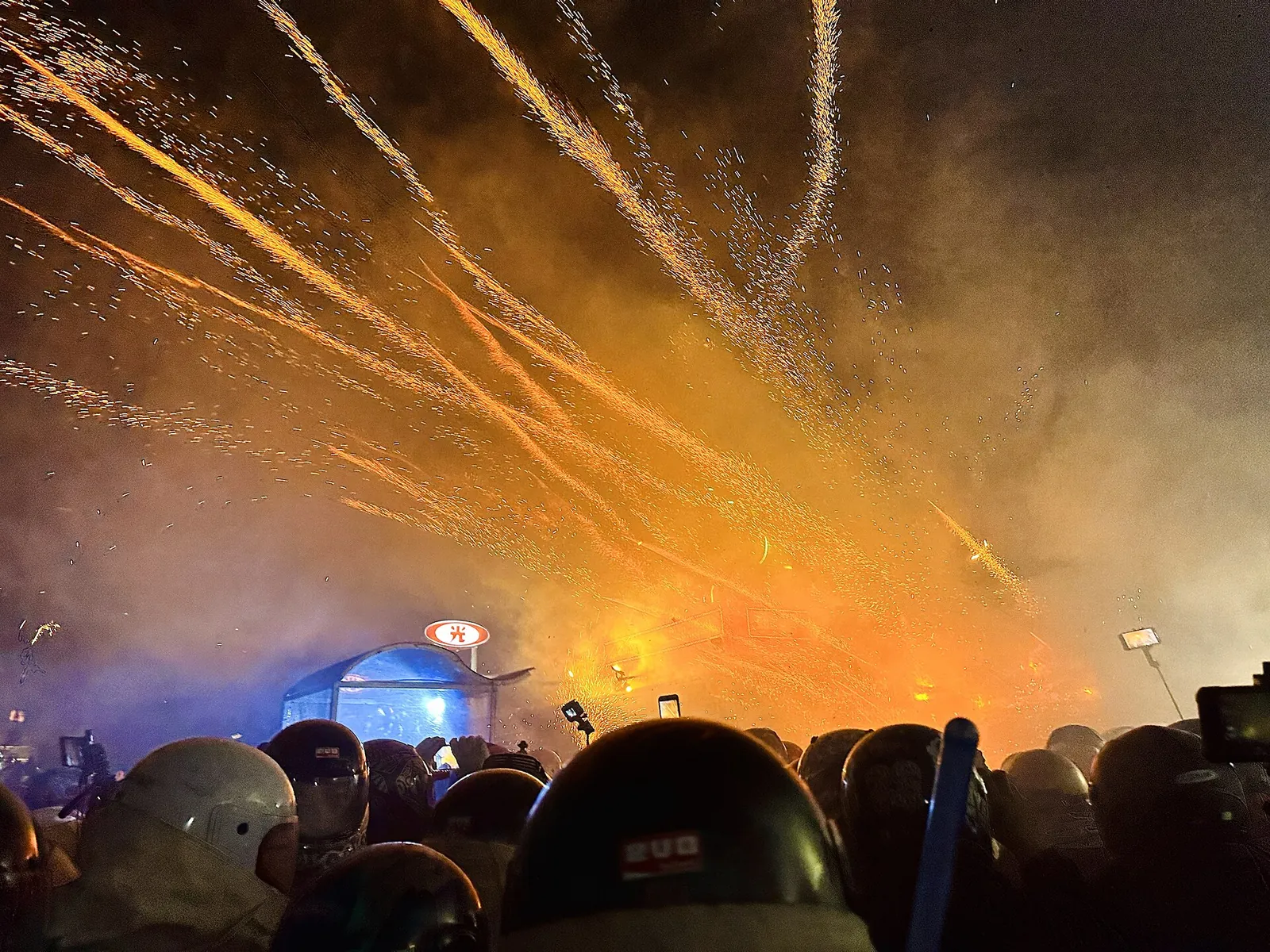 Tłum w hełmach naprzeciw salwy rakiet odpalanych z butelek nocą w Yanshui