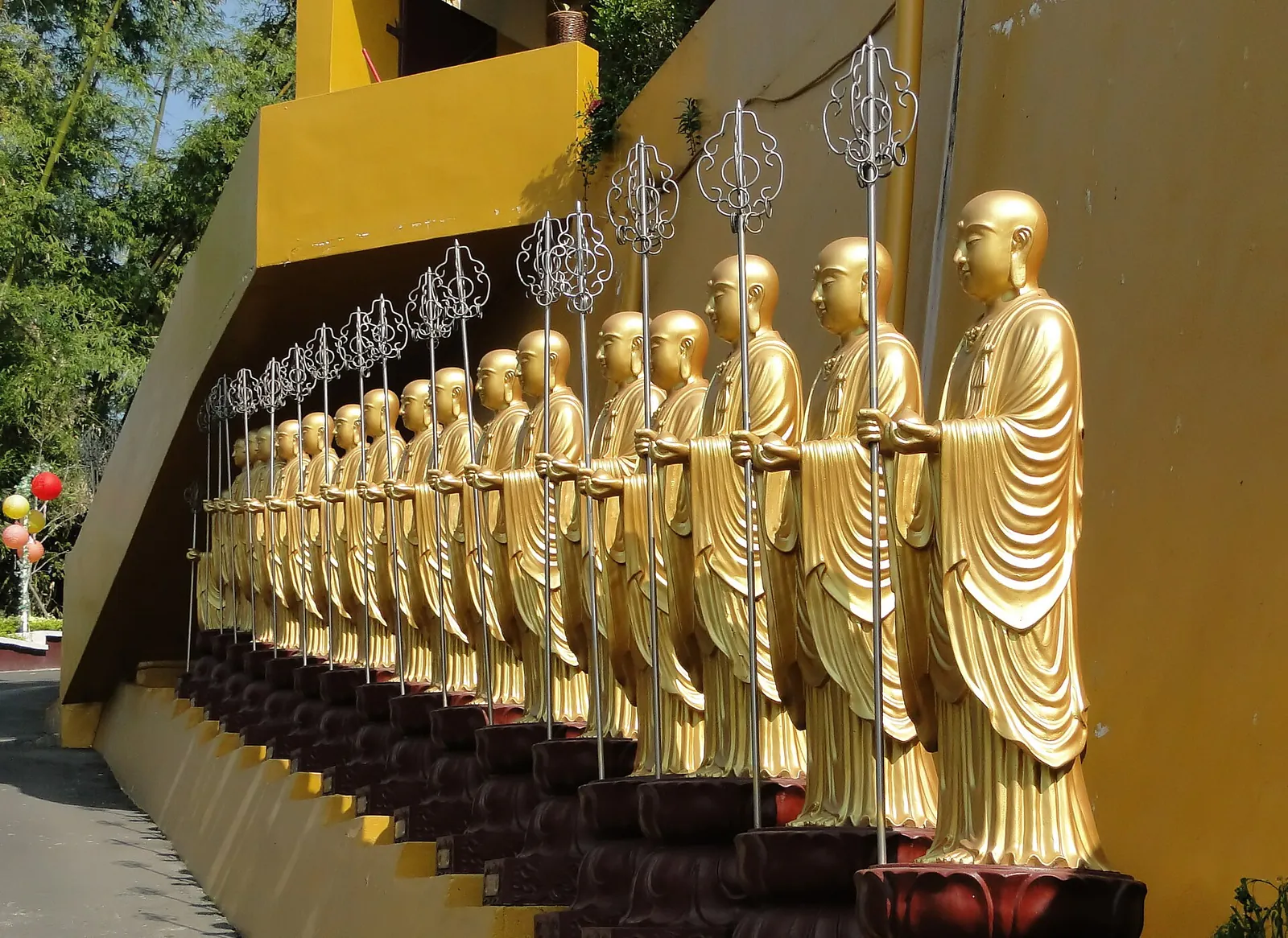 Fila di statue buddhiste dorate al monastero di Fo Guang Shan