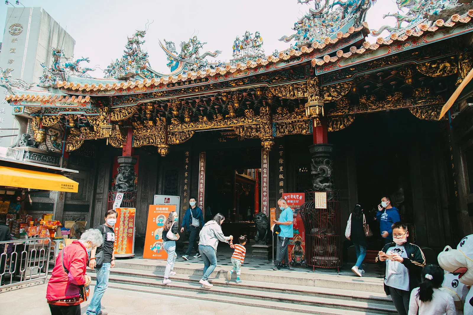 Fedeli fuori dall’ingresso decorato del Tempio del Dio della Città di Hsinchu