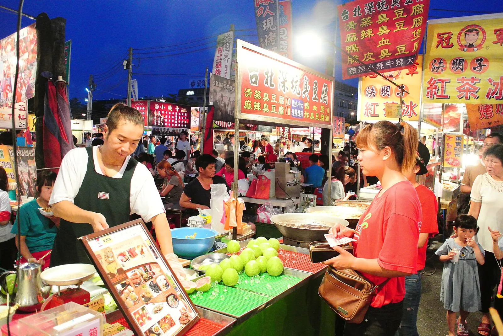 Prodejce a zákazníci vedle jídelního stánku na Garden Night Market