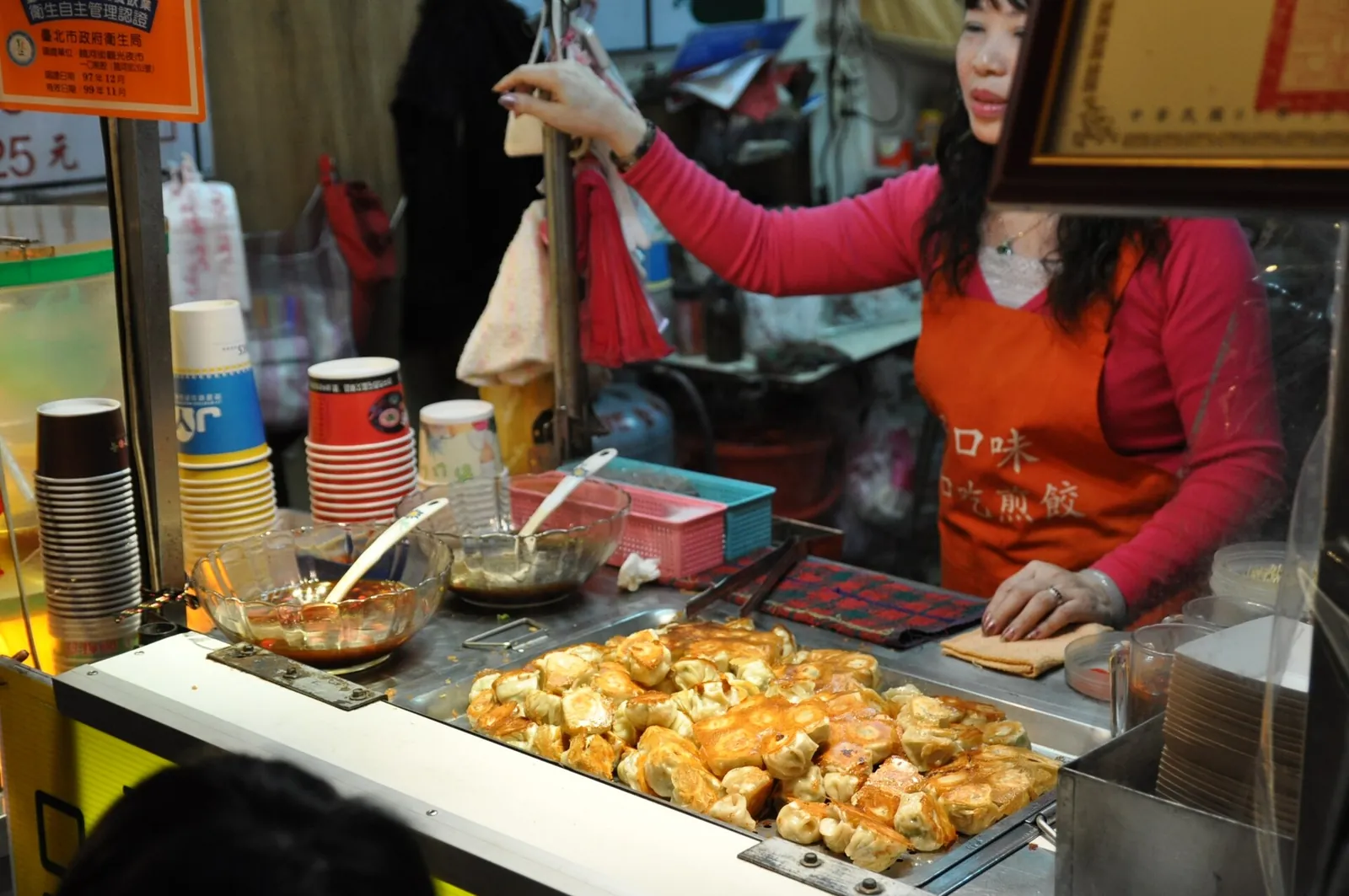 Prodejce vedle pánve s knedlíčky na Raohe Street Night Market