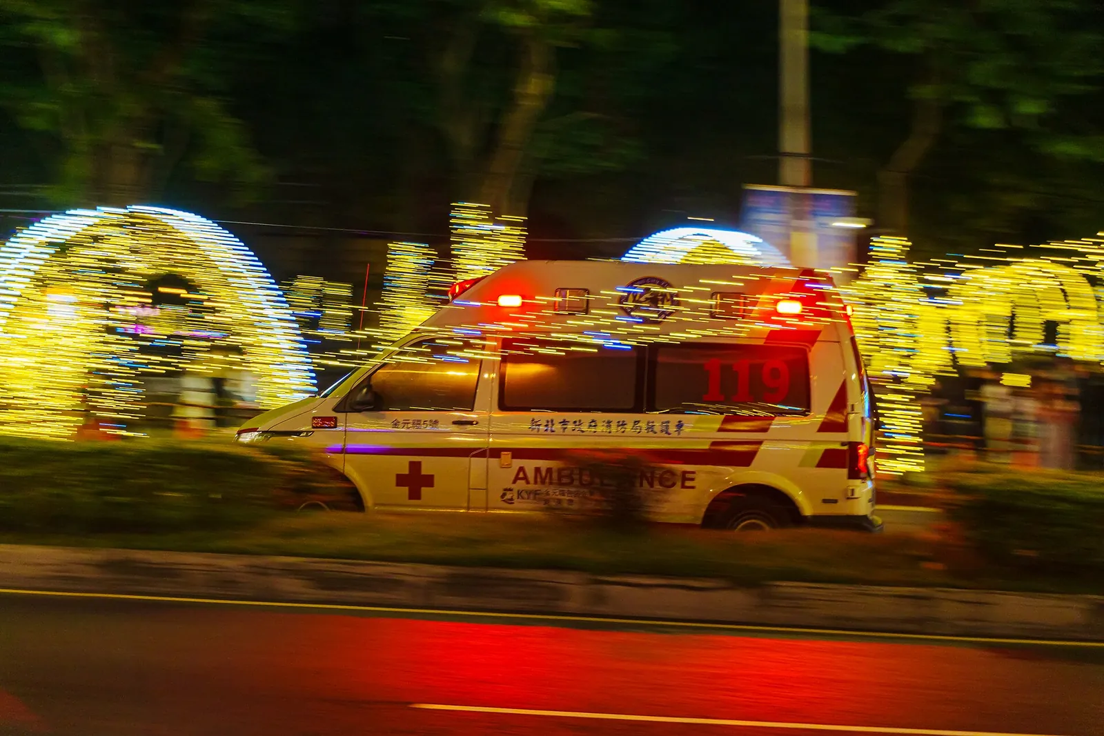 Sanitka New Taipei City míjející osvětlené pouliční dekorace