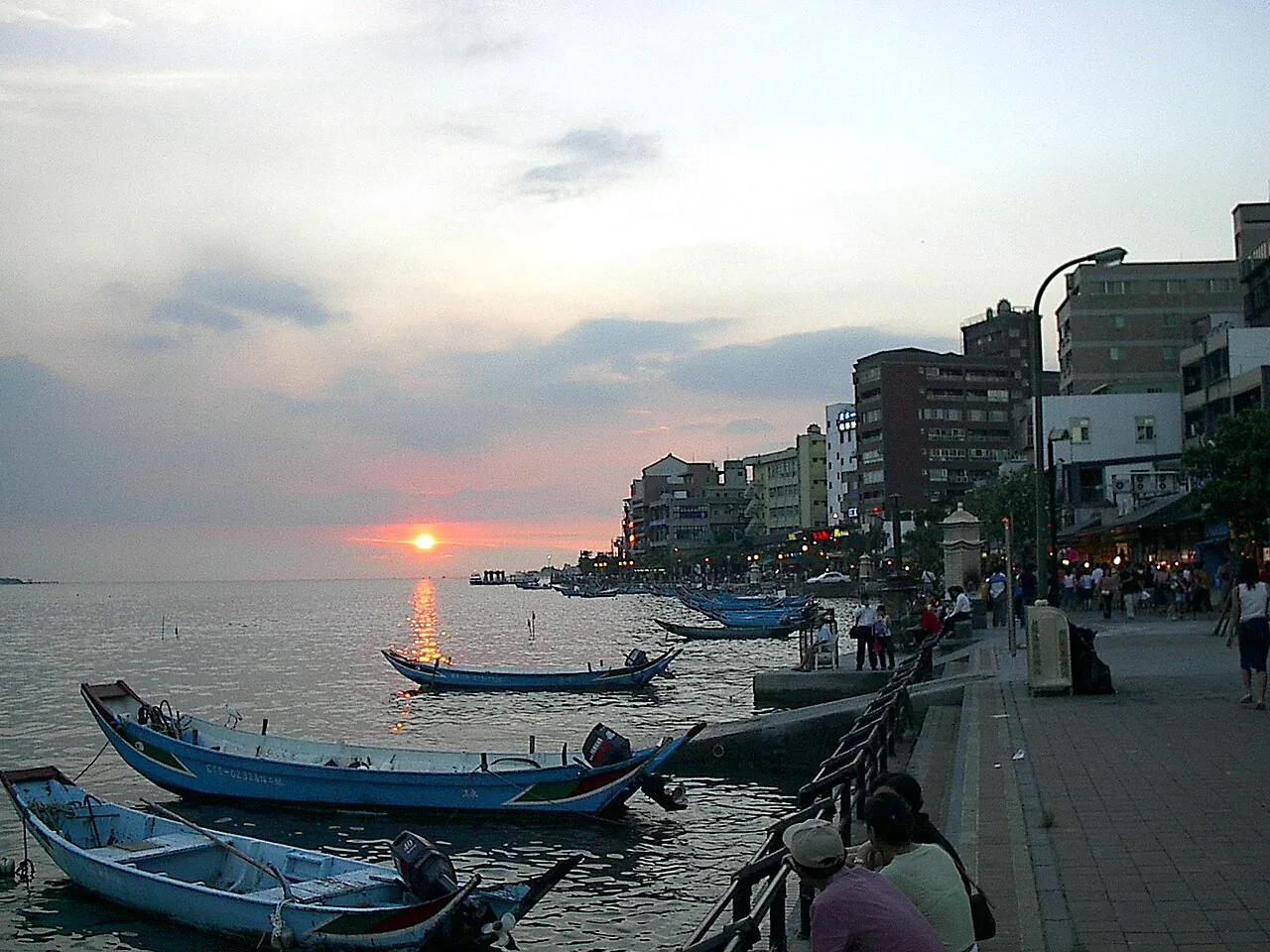 Lodě u nábřeží Tamsui při západu slunce