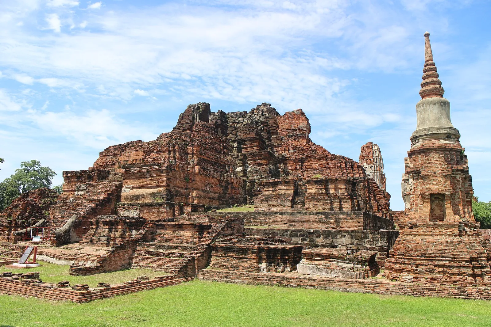 Ruine de cărămidă și un chedi alb la Wat Mahathat, în Ayutthaya, într-o zi senină