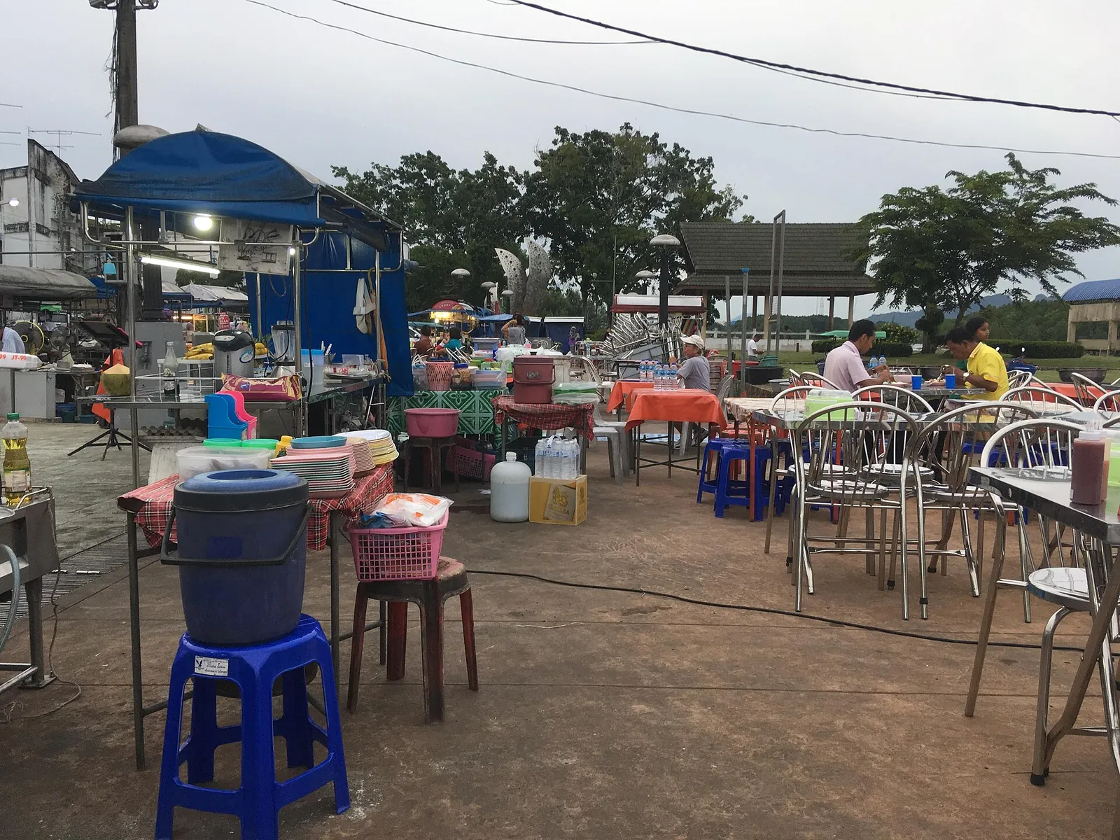 Stoly a stánky s jídlem u řeky ve městě Krabi