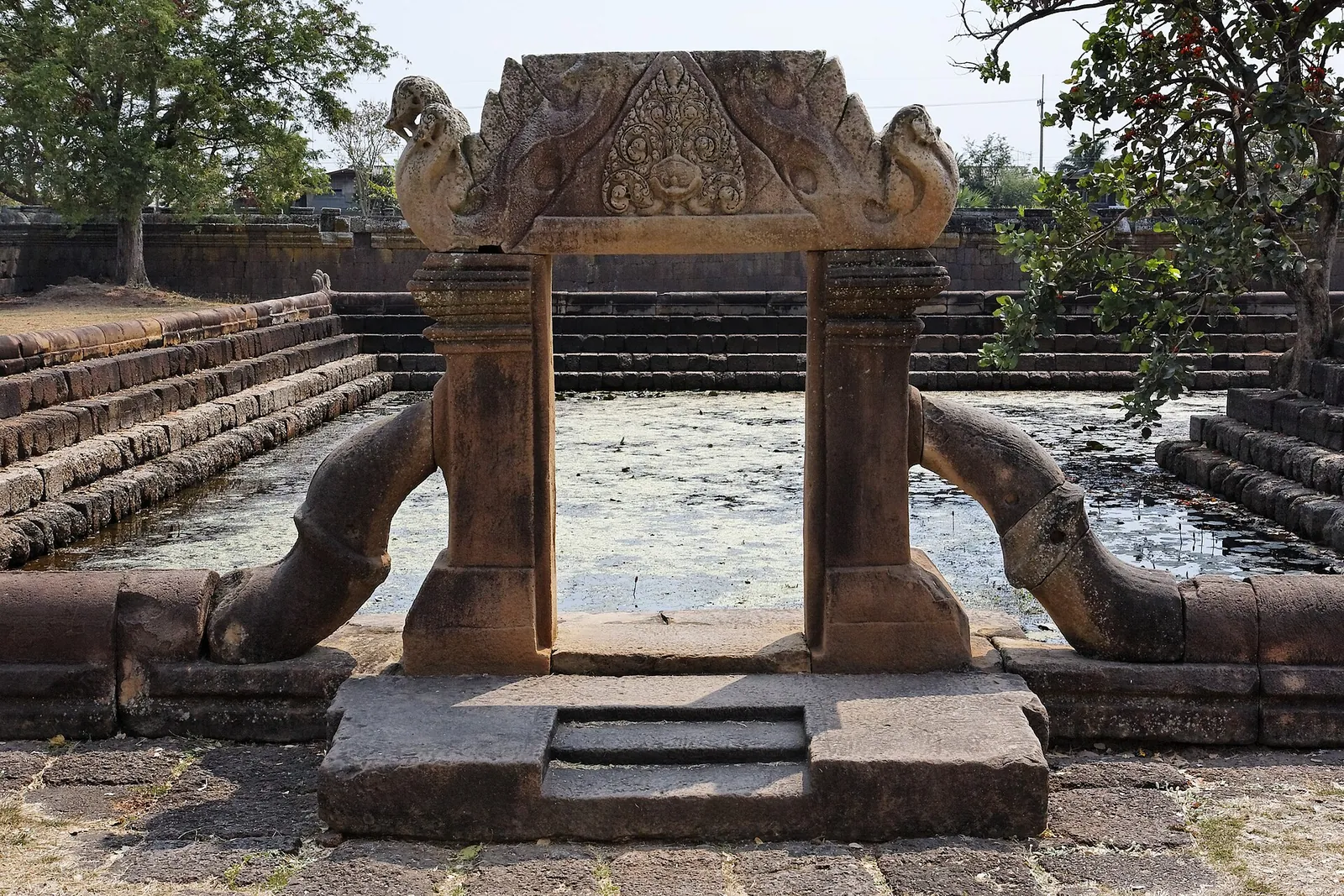 A carved sandstone gateway between naga balustrades over one of Muang Tam's ponds