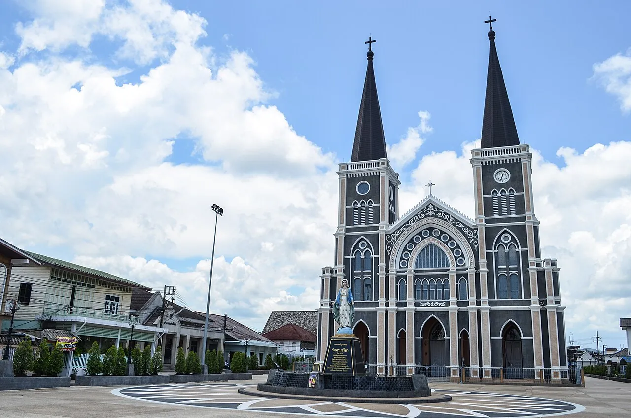 The twin-spired grey facade of the Cathedral of the Immaculate Conception under a blue sky