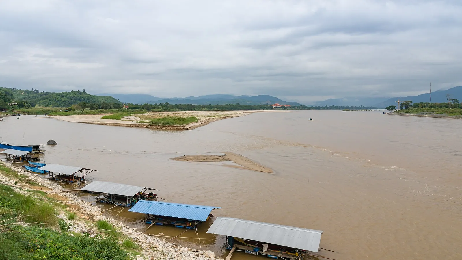 The wide brown Mekong at Sop Ruak with moored boats and the hills of Laos and Myanmar beyond