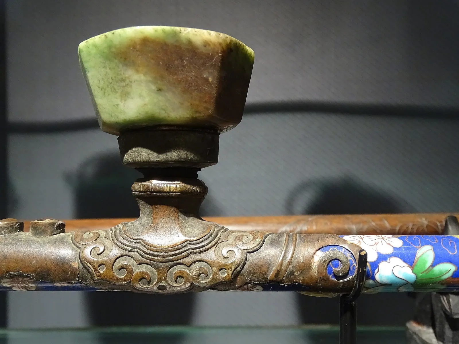 An ornate antique opium pipe displayed in a glass case at the Hall of Opium