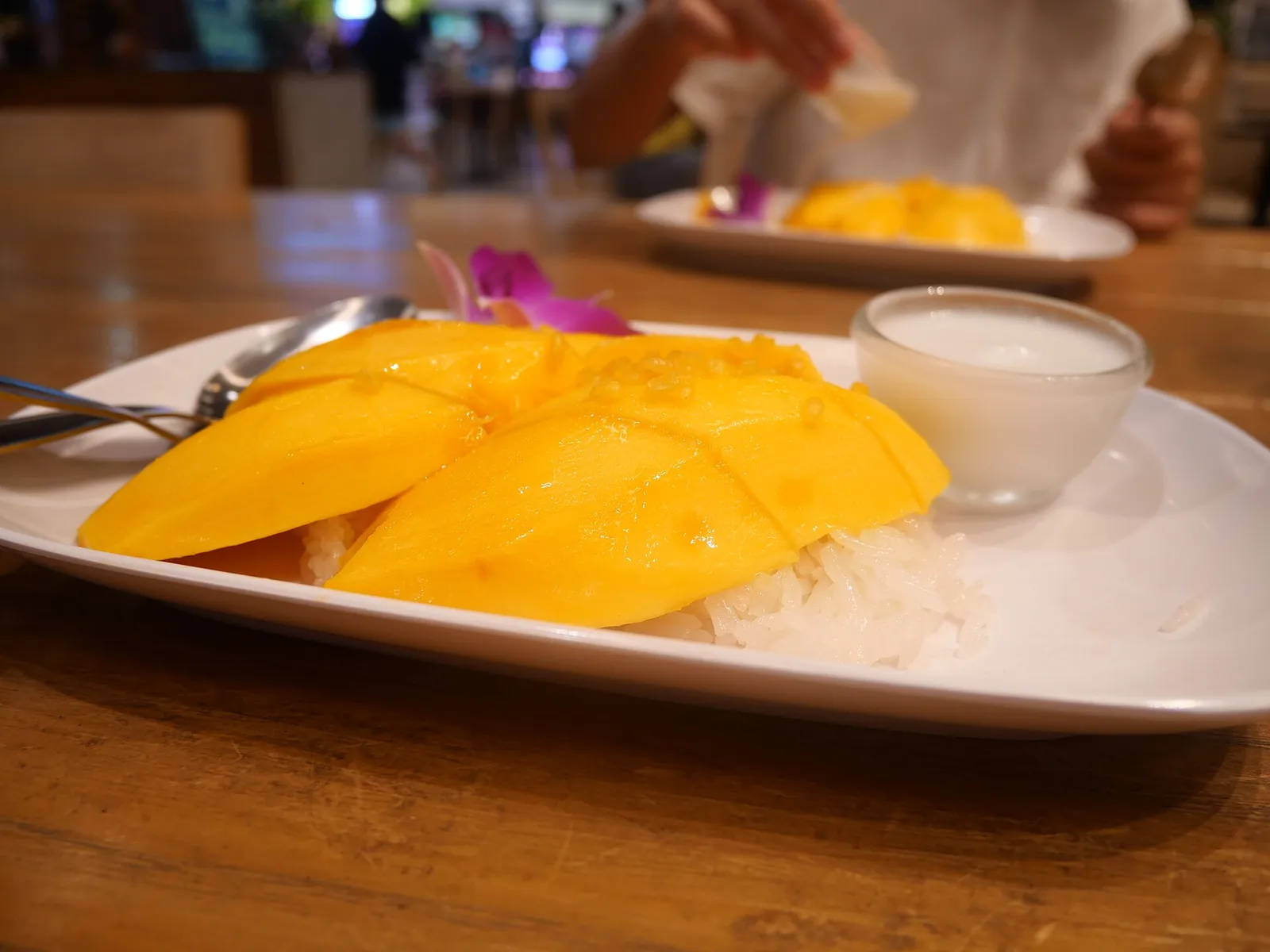 Mango en rodajas y arroz pegajoso servido en un plato blanco en Tailandia