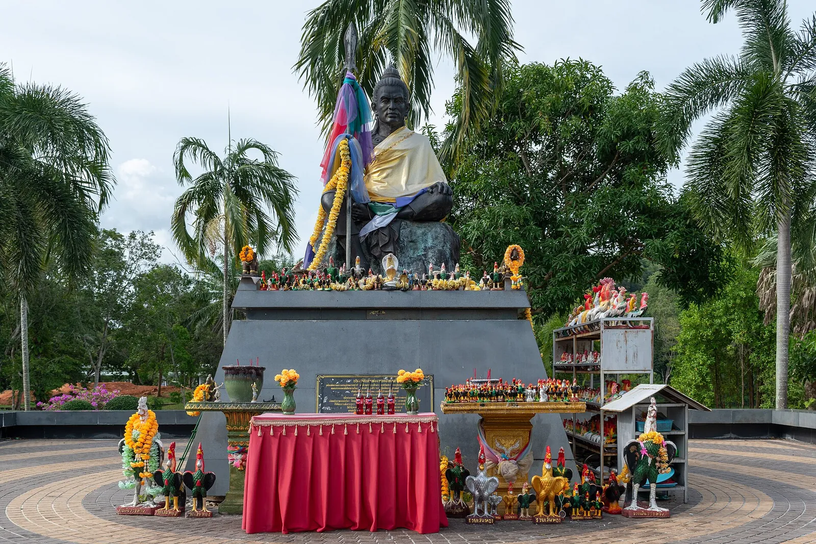 A large seated Buddha shrine with offerings in Hat Yai Municipal Park