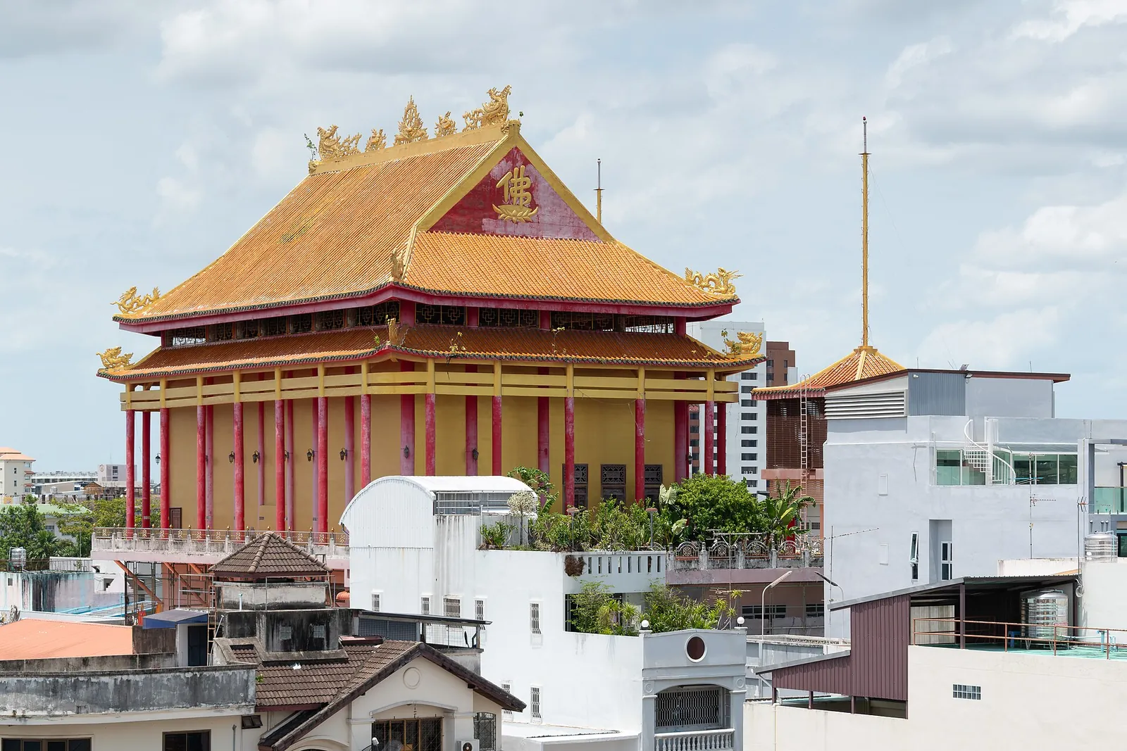 The golden-roofed hall of Wat Thawararam above the rooftops of Hat Yai