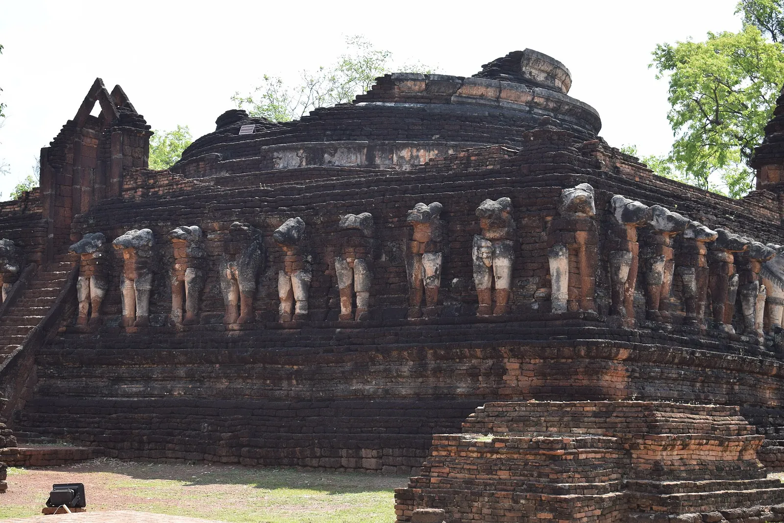 A row of elephant sculptures around the laterite base of Wat Chang Rob