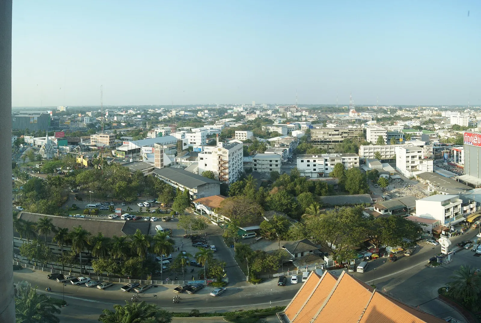 View over the low-rise city of Khon Kaen with trees and a temple roof
