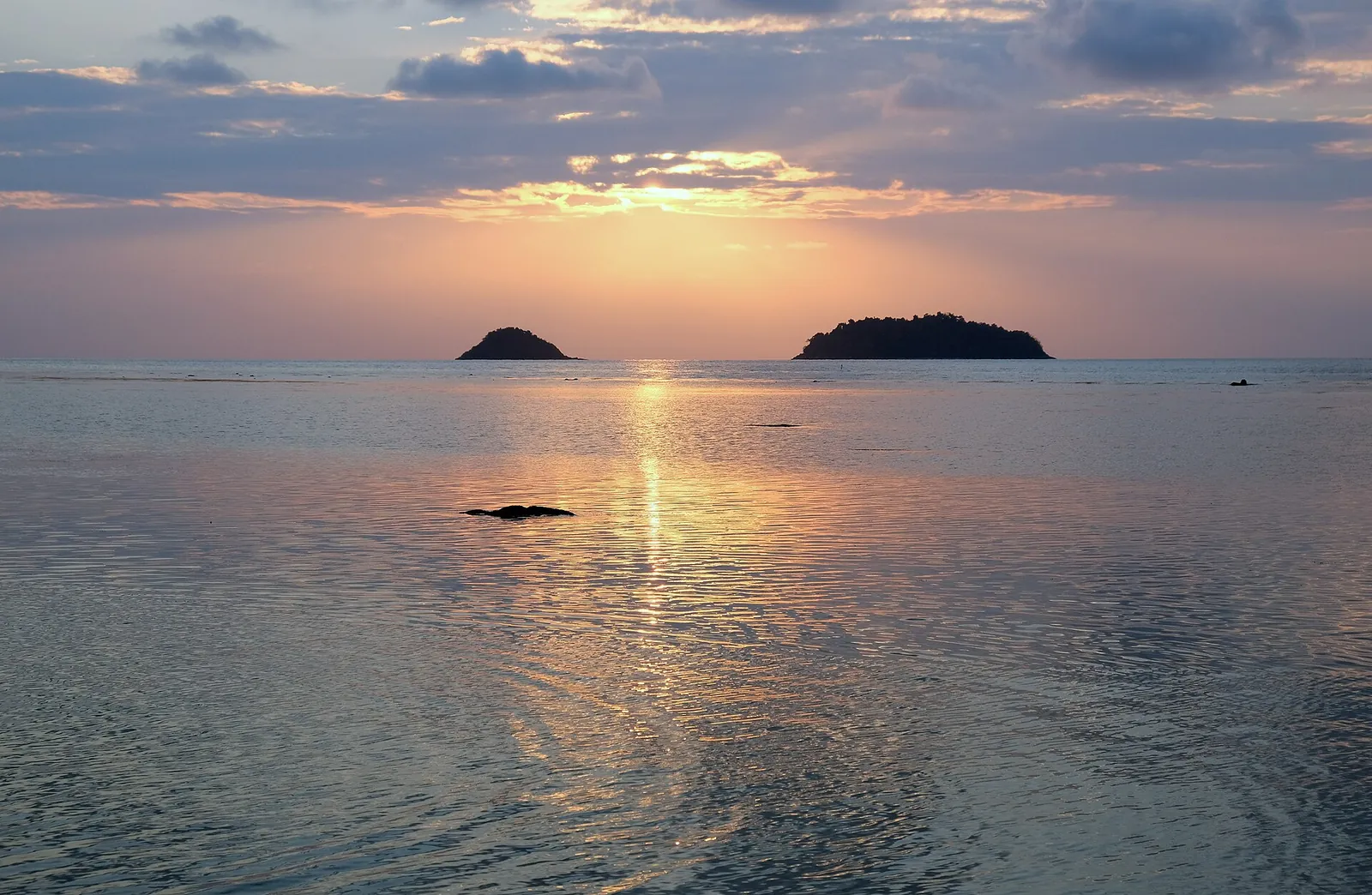 Die Sonne geht über kleinen Inseln vor der Westküste von Koh Chang unter