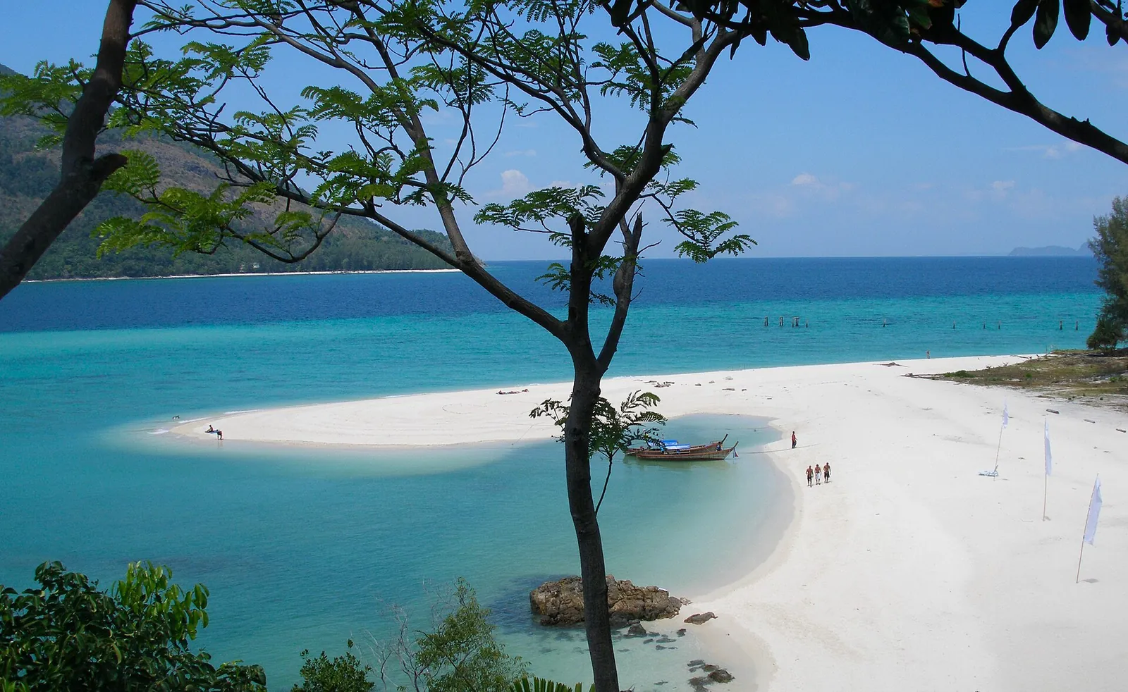 A white sand spit curving into turquoise water off Koh Lipe framed by trees