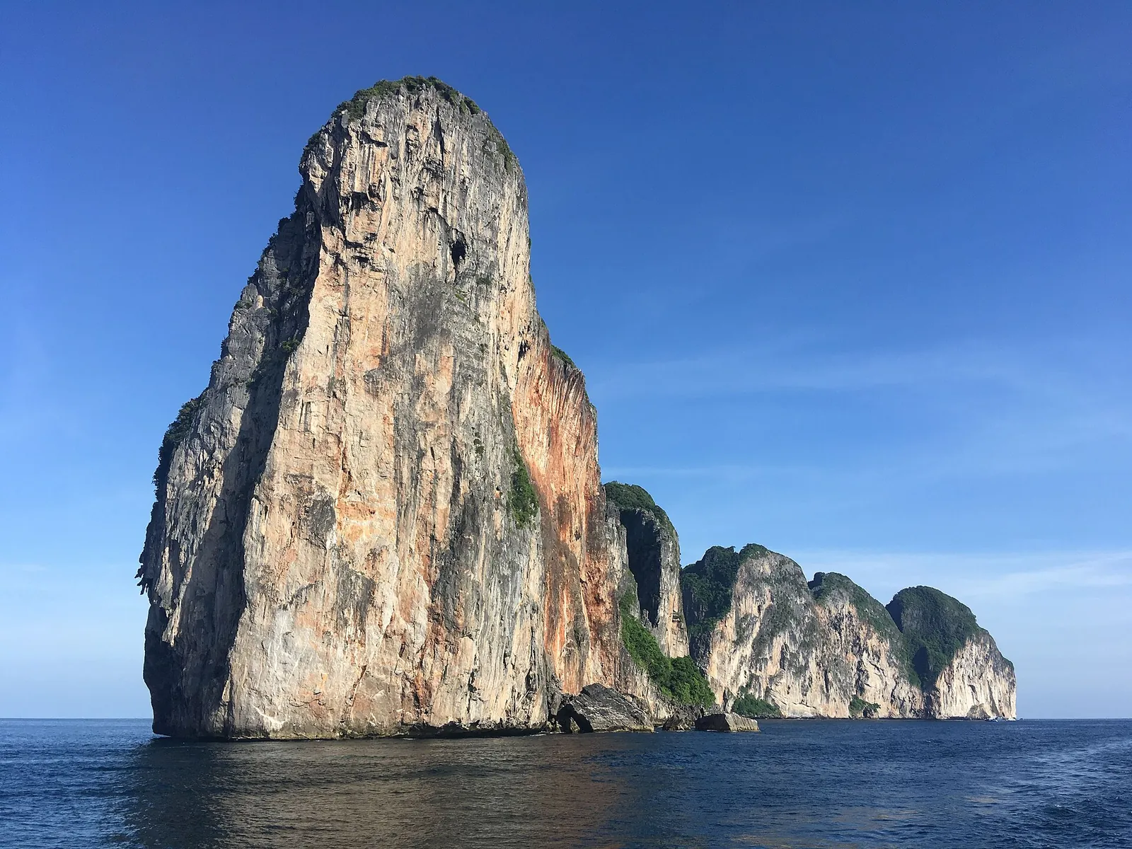 A towering limestone cliff of Phi Phi Leh rising from deep blue sea