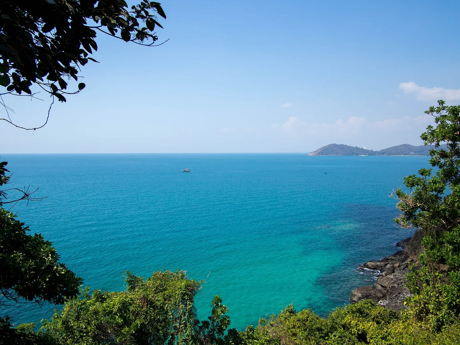 Turquoise sea seen through trees from a headland on Koh Samet
