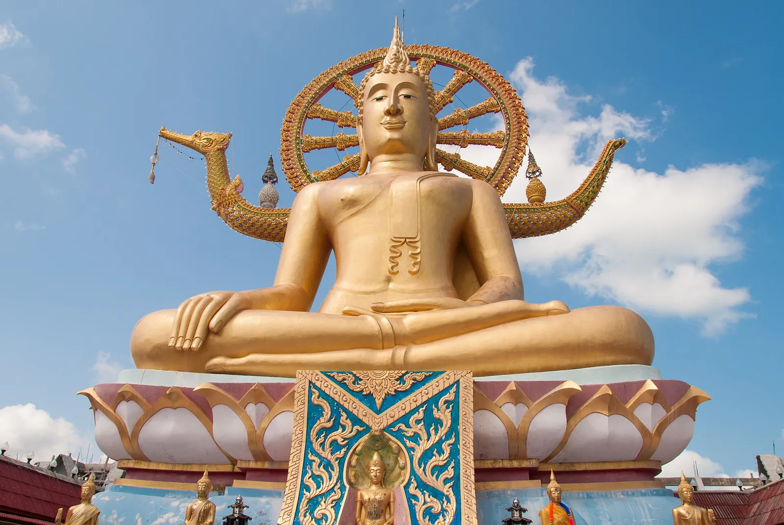 The golden seated Big Buddha of Wat Phra Yai against a blue sky