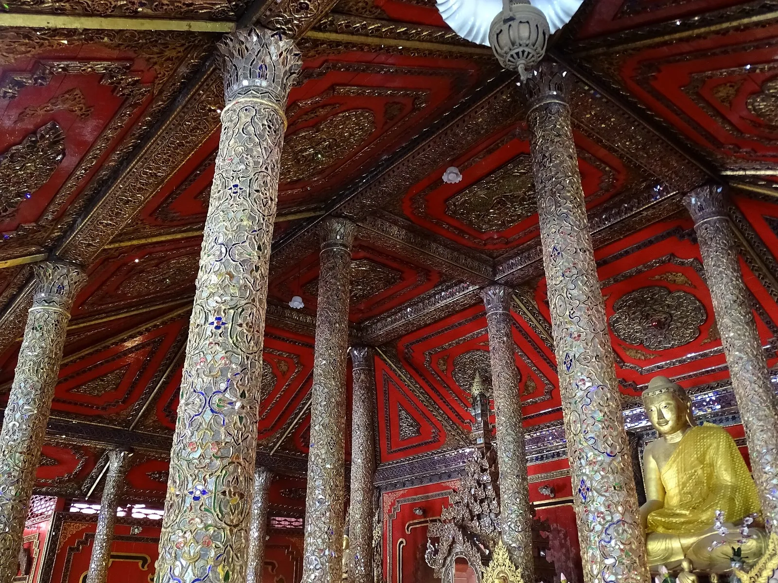 Säulen mit Spiegelmosaik und eine rote Decke im Inneren des Wat Si Rong Mueang