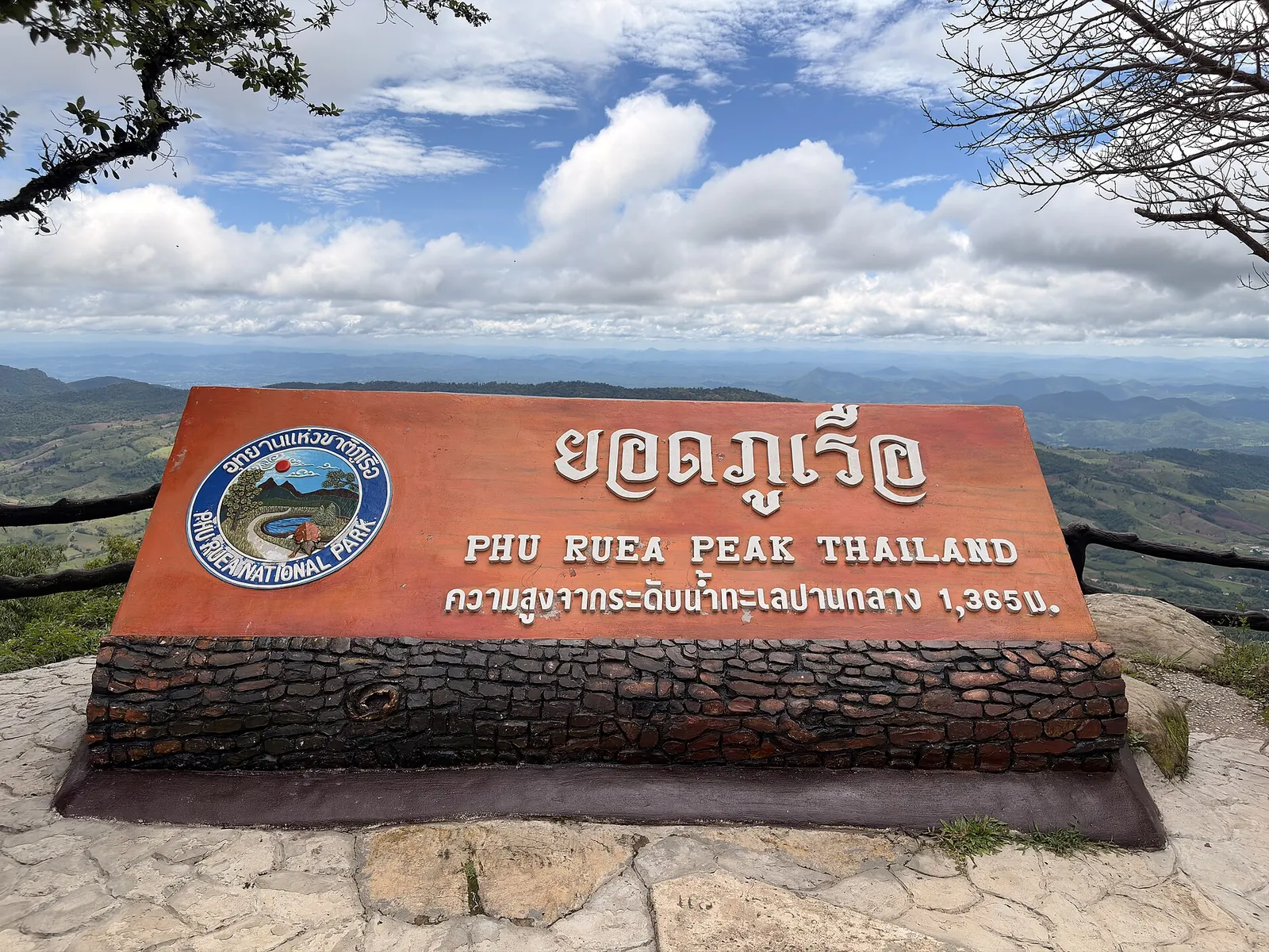 The summit sign of Phu Ruea giving its height of 1,365 metres above a misty valley