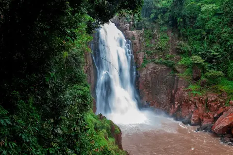 La cascata di Haew Narok che precipita su una scogliera di roccia rossa in una gola boscosa