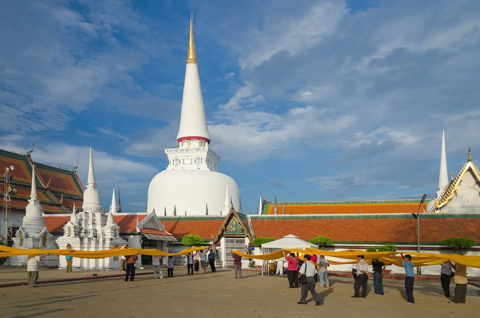 The tall white bell-shaped chedi of Wat Phra Mahathat Woramahawihan with its gilded spire