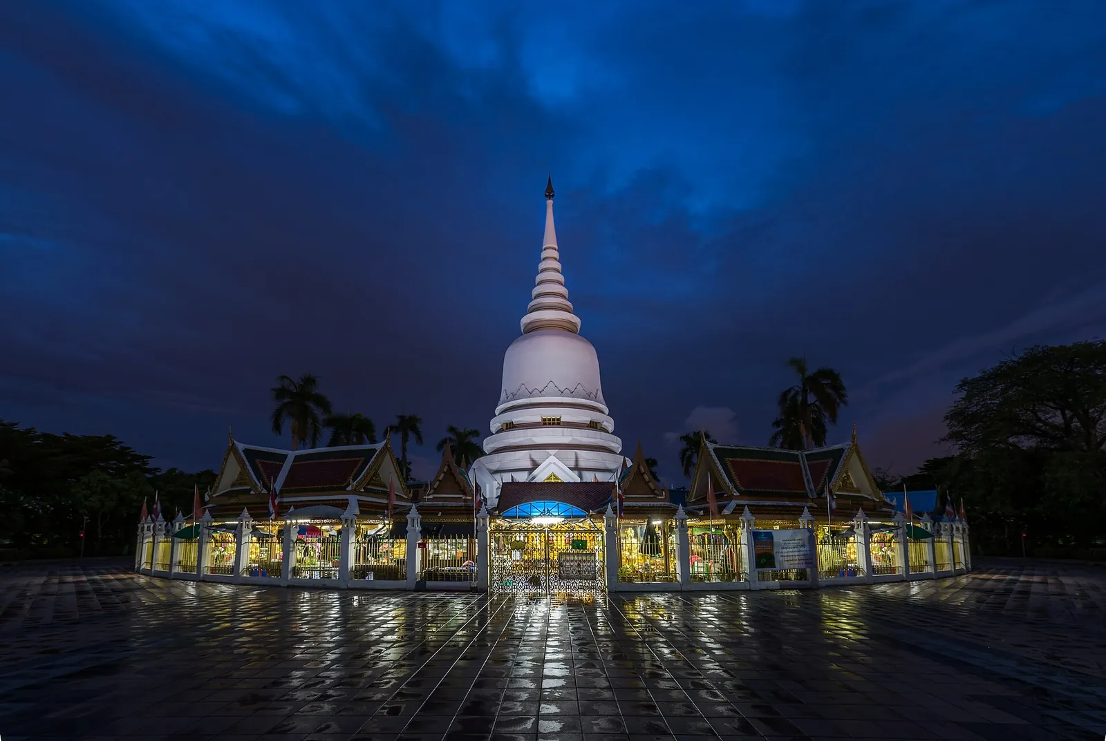 The great chedi and surrounding halls of Wat Phra Mahathat lit at dusk