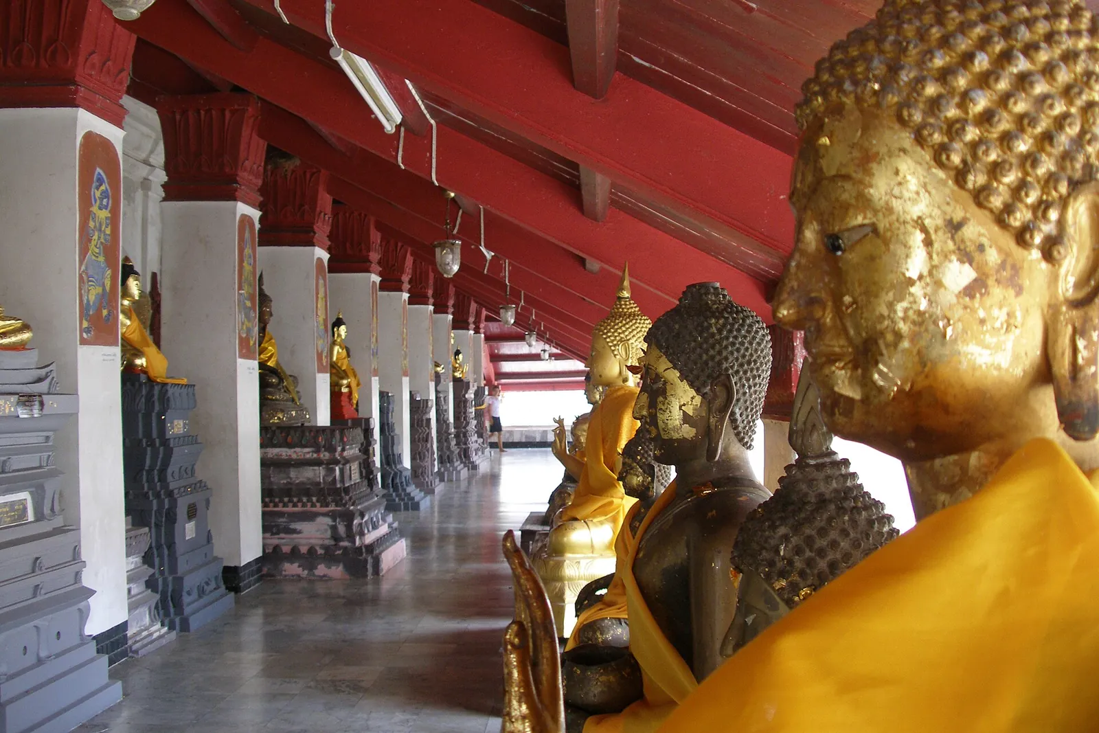 Gilded Buddha images lining a temple cloister in Nakhon Si Thammarat