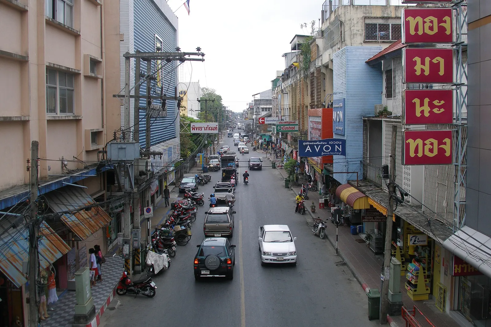 A busy main street of Nakhon Si Thammarat with shophouses and signs