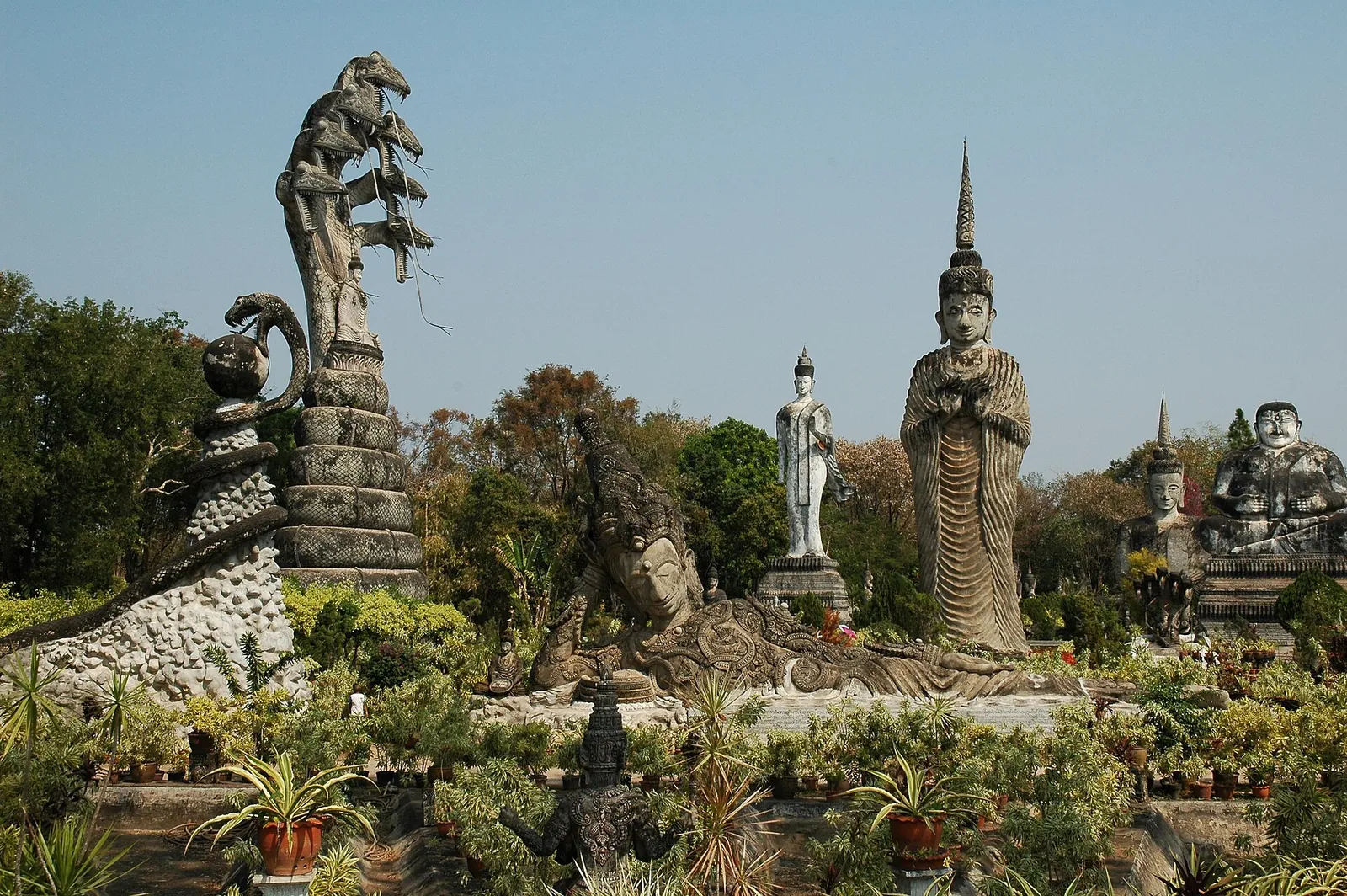 Giant concrete sculptures of a many-headed naga, Buddhas and deities in the gardens of Sala Kaew Ku
