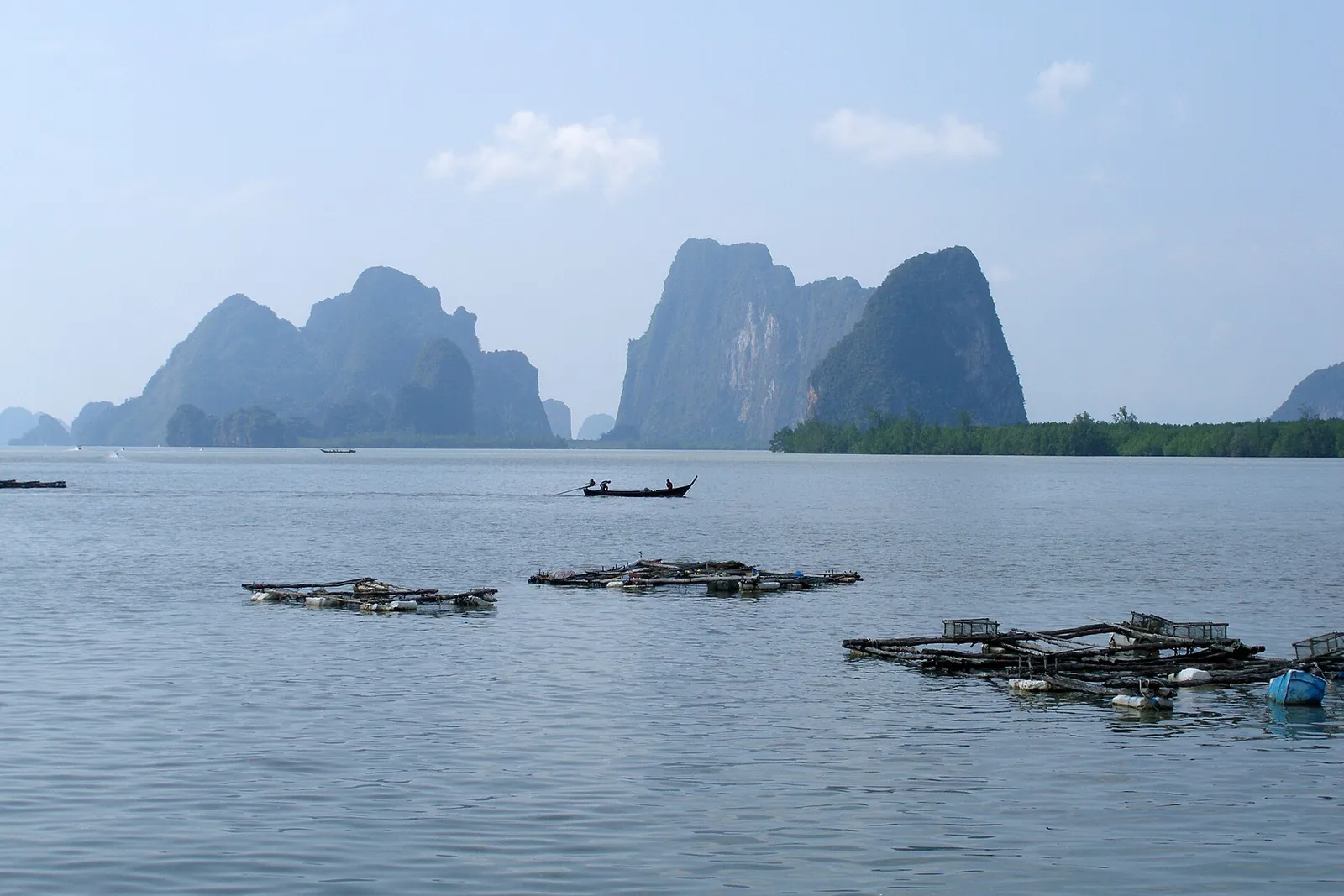 Limestone karst islands rising from the calm green water of Phang Nga Bay