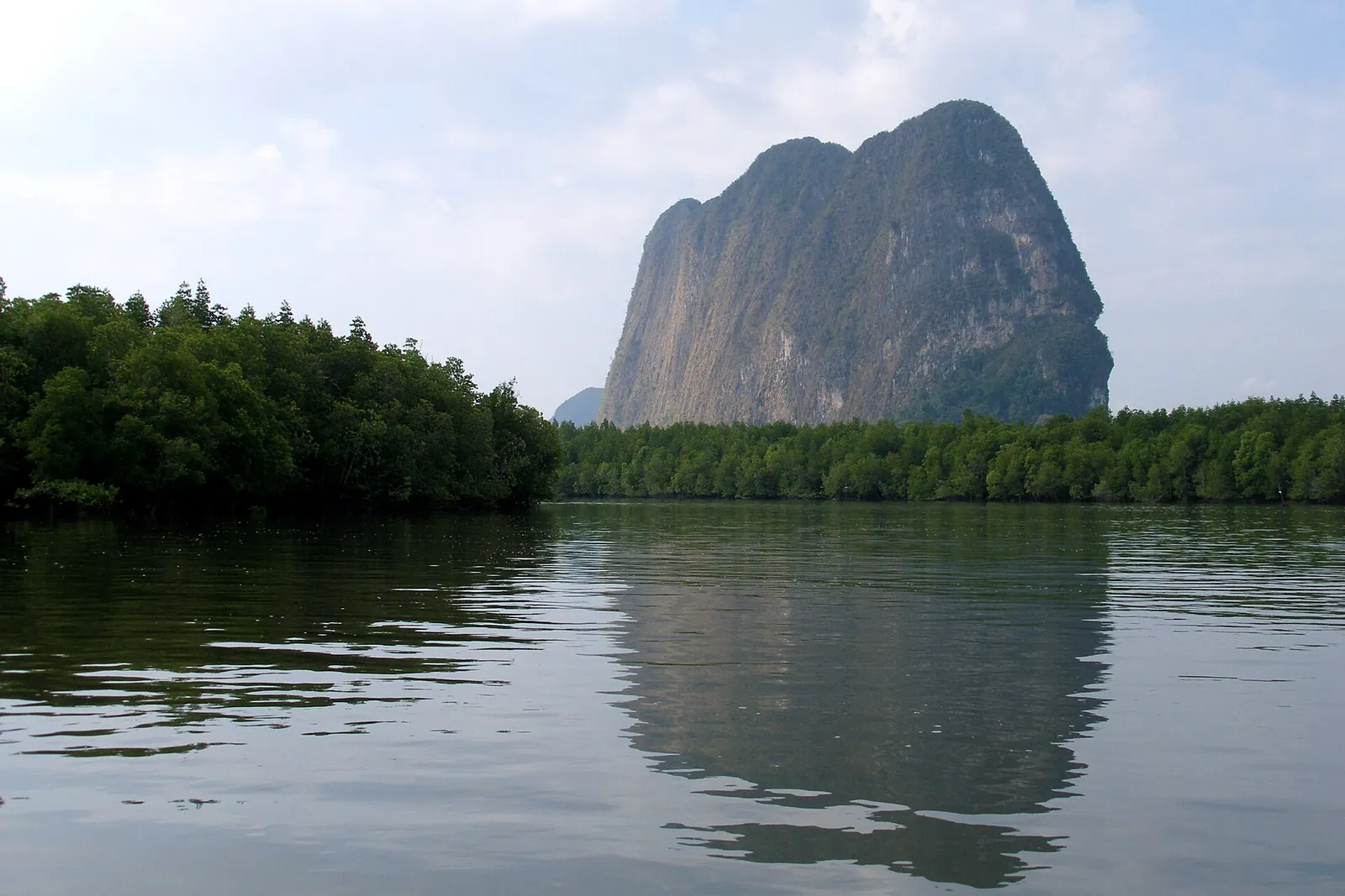 A mangrove-lined river winding into Phang Nga Bay between limestone hills