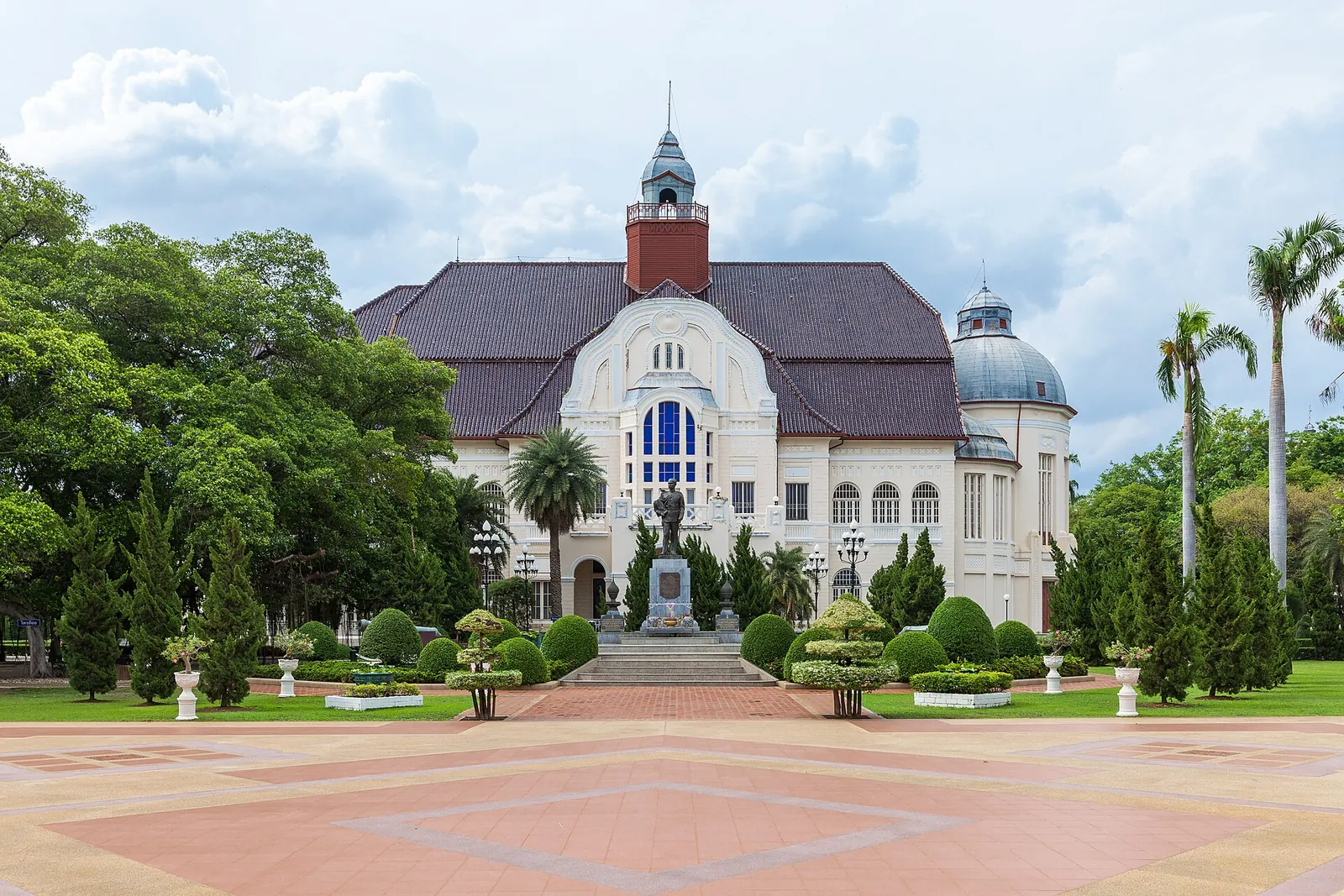 The European-style facade of Phra Ram Ratchaniwet palace behind a formal garden