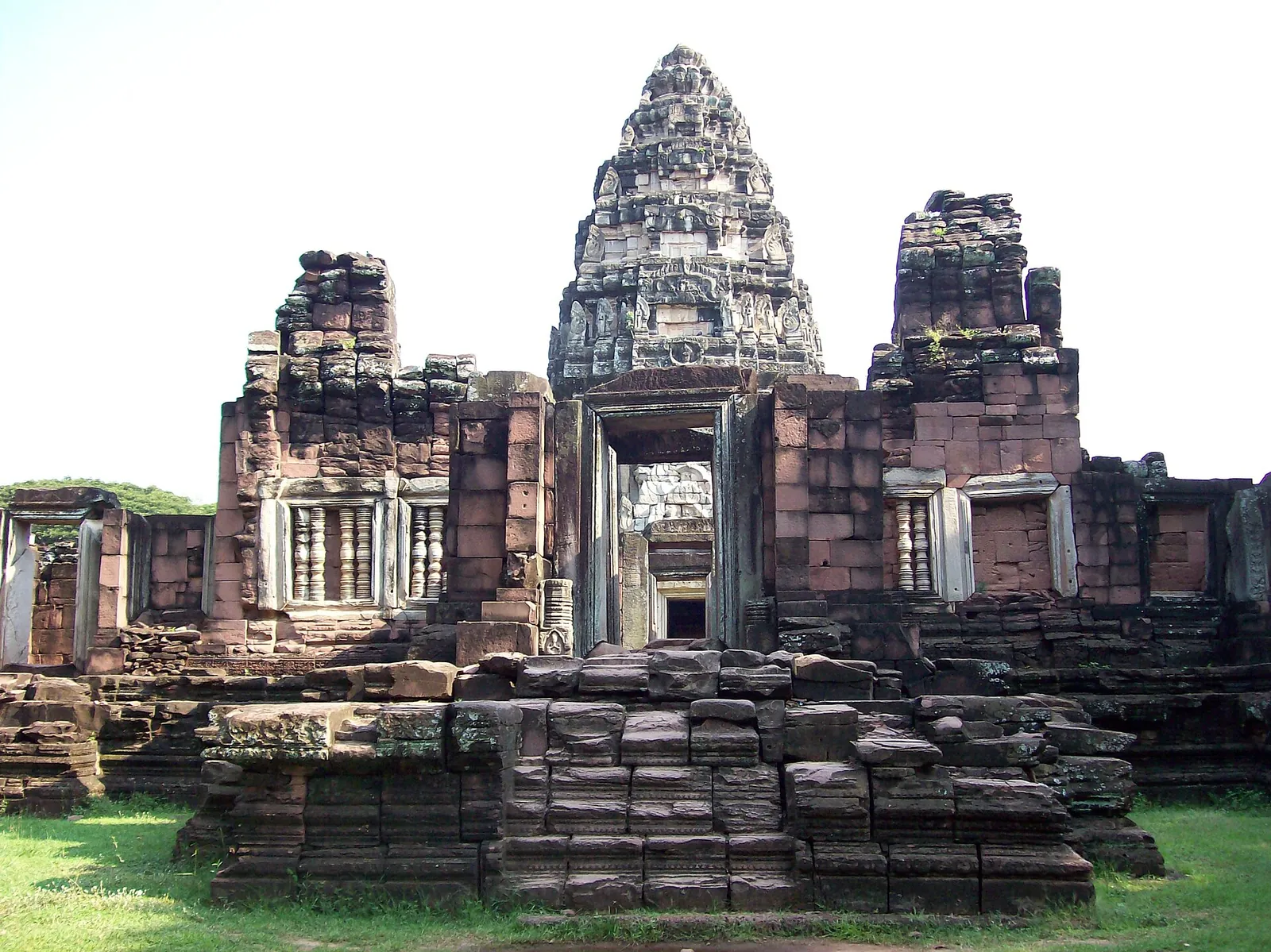 The grey sandstone central tower of Prasat Hin Phimai rising above its galleries and a stepped terrace