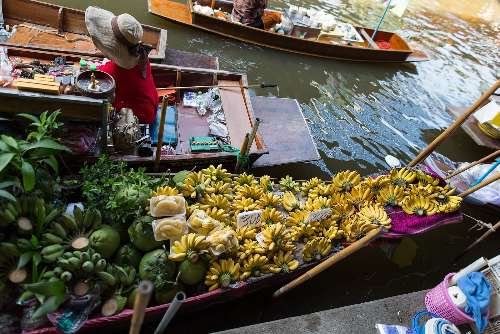 En selgers robåt full av bananer og frukt på en kanal i Damnoen Saduak