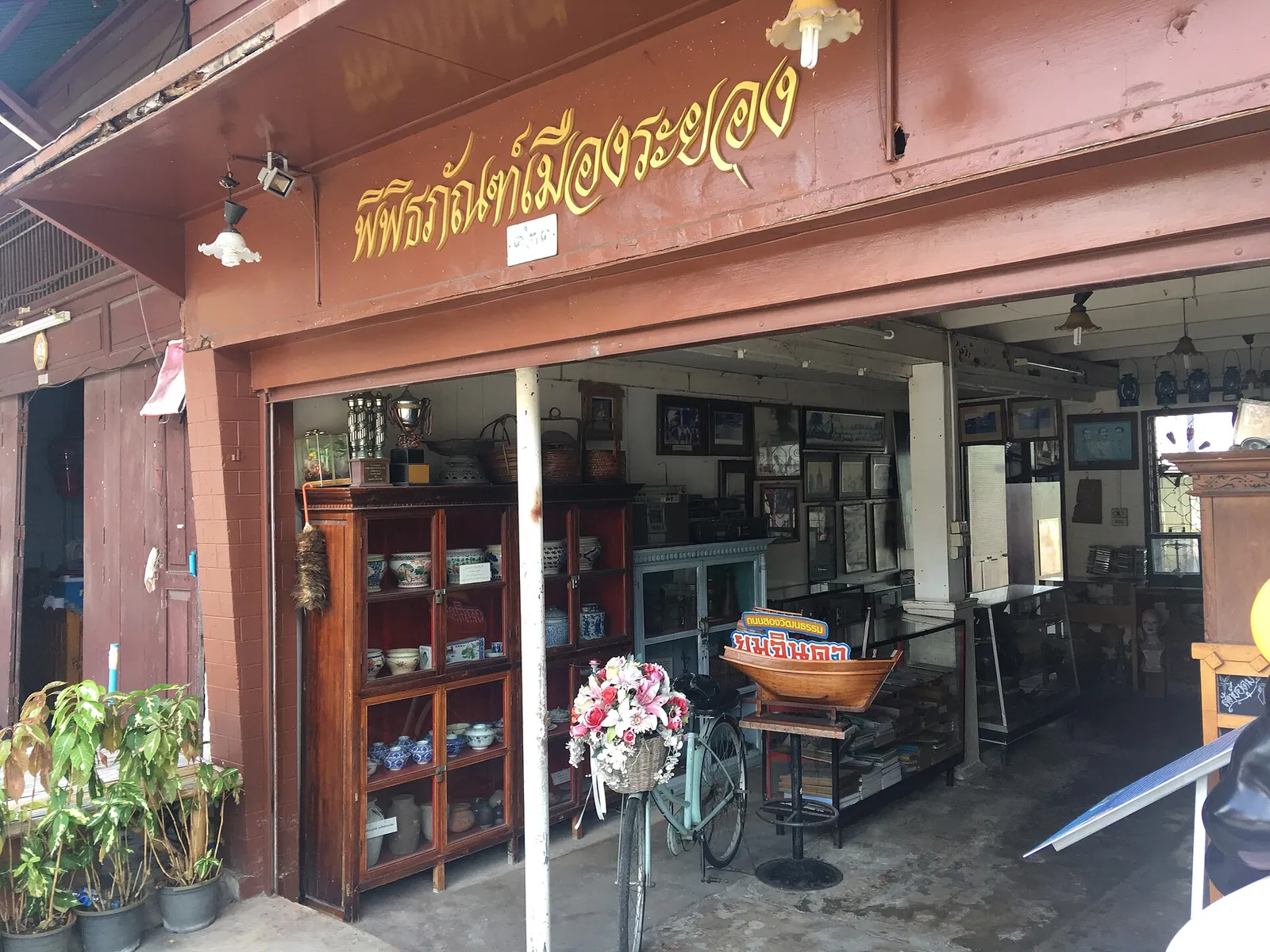 The wooden shopfront of the Rayong Museum on Yomjinda Road with old objects on display