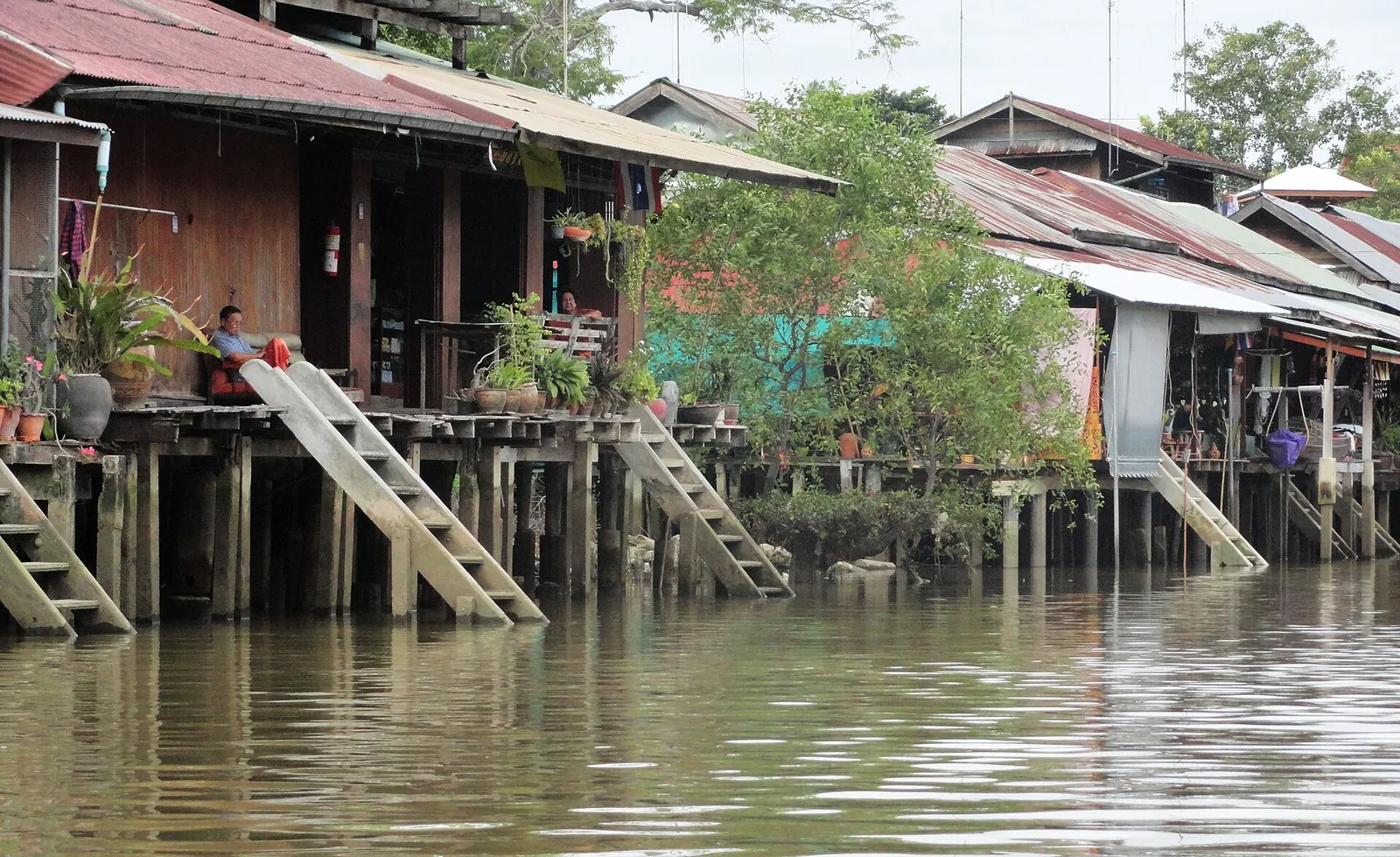 Wooden stilt houses with steps down to the water along a canal in Amphawa