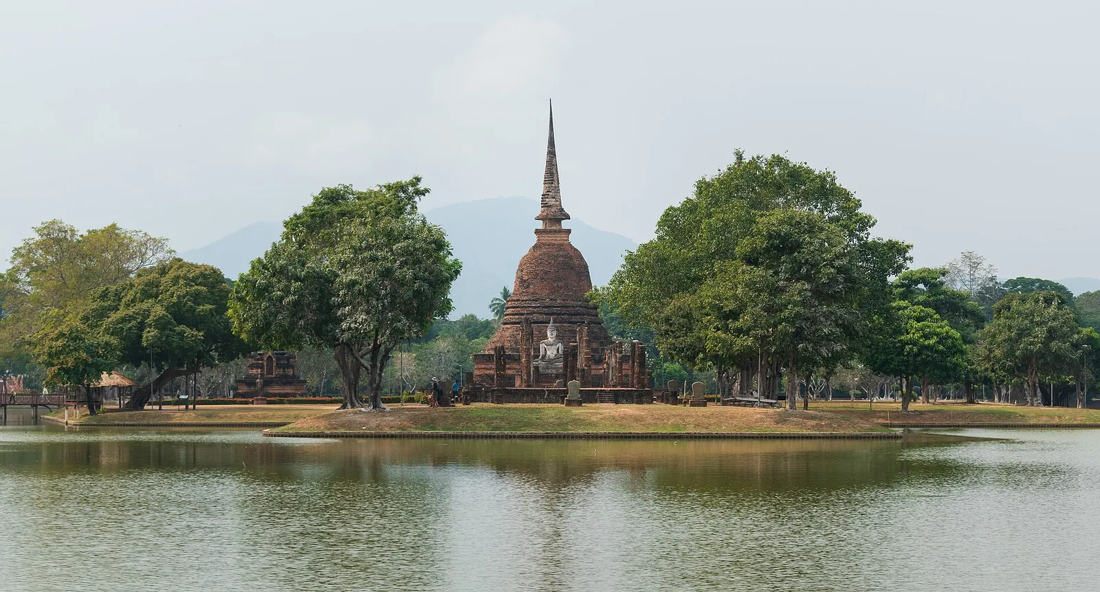 The bell-shaped chedi of Wat Sa Si on an island seen across a pond