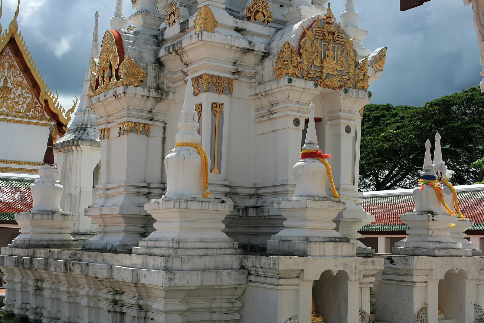 Close view of the carved white tiers and gilded details of the Chaiya chedi