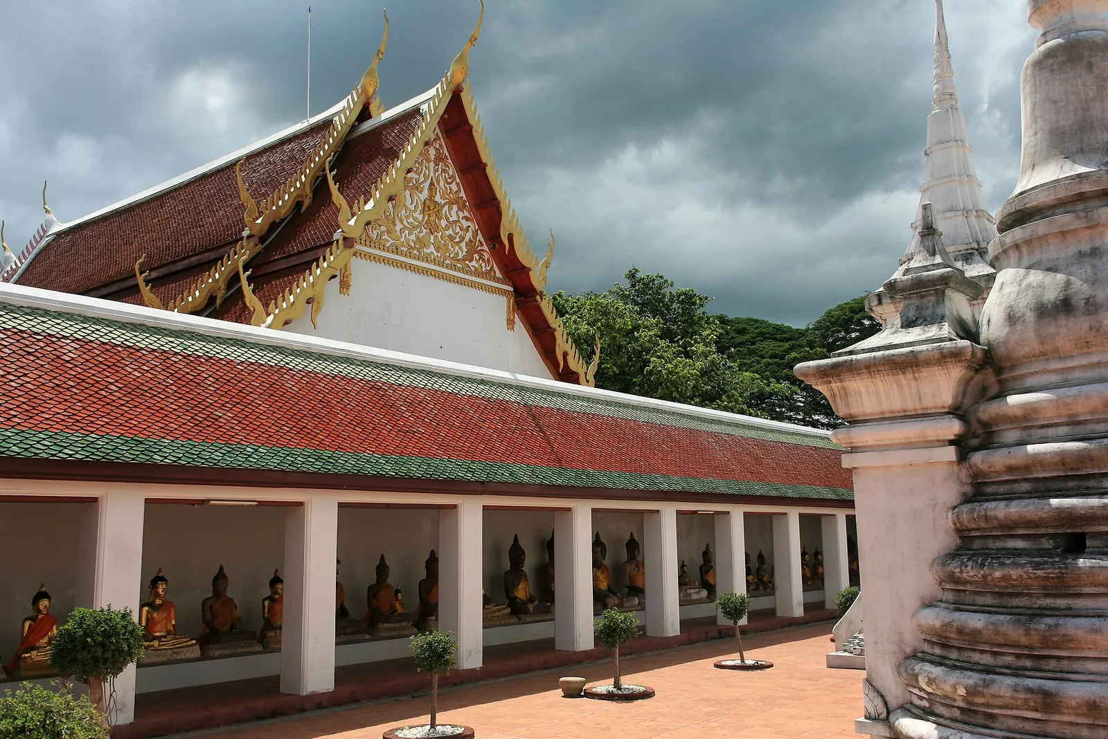A cloister of seated Buddha images along the gallery of Wat Phra Borommathat Chaiya