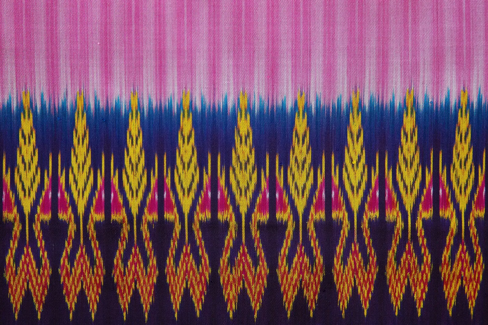 A length of handwoven silk with yellow, blue and pink patterns