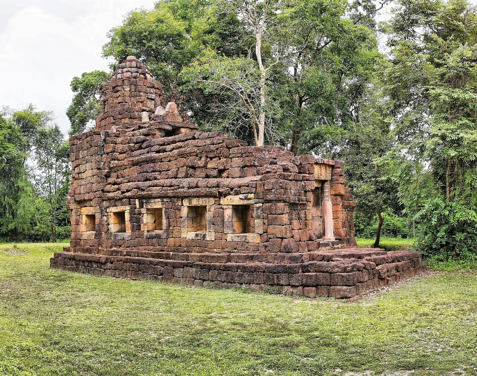 The ruined laterite and sandstone chapel of Prasat Ta Muen among trees